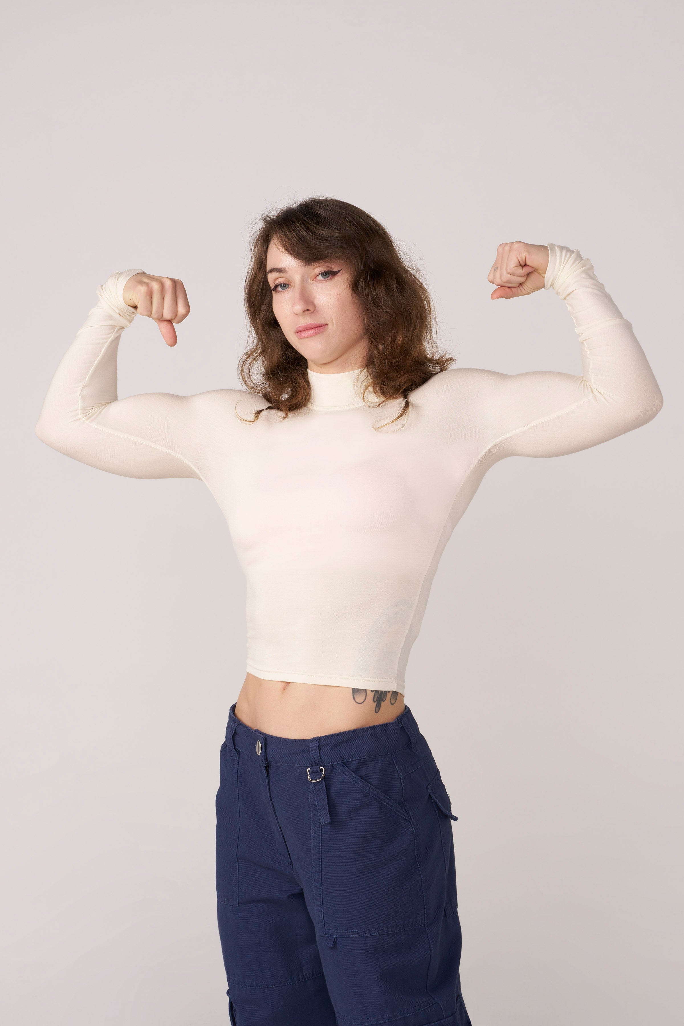 Front view of the sleek sheer long sleeve crop top on a model.