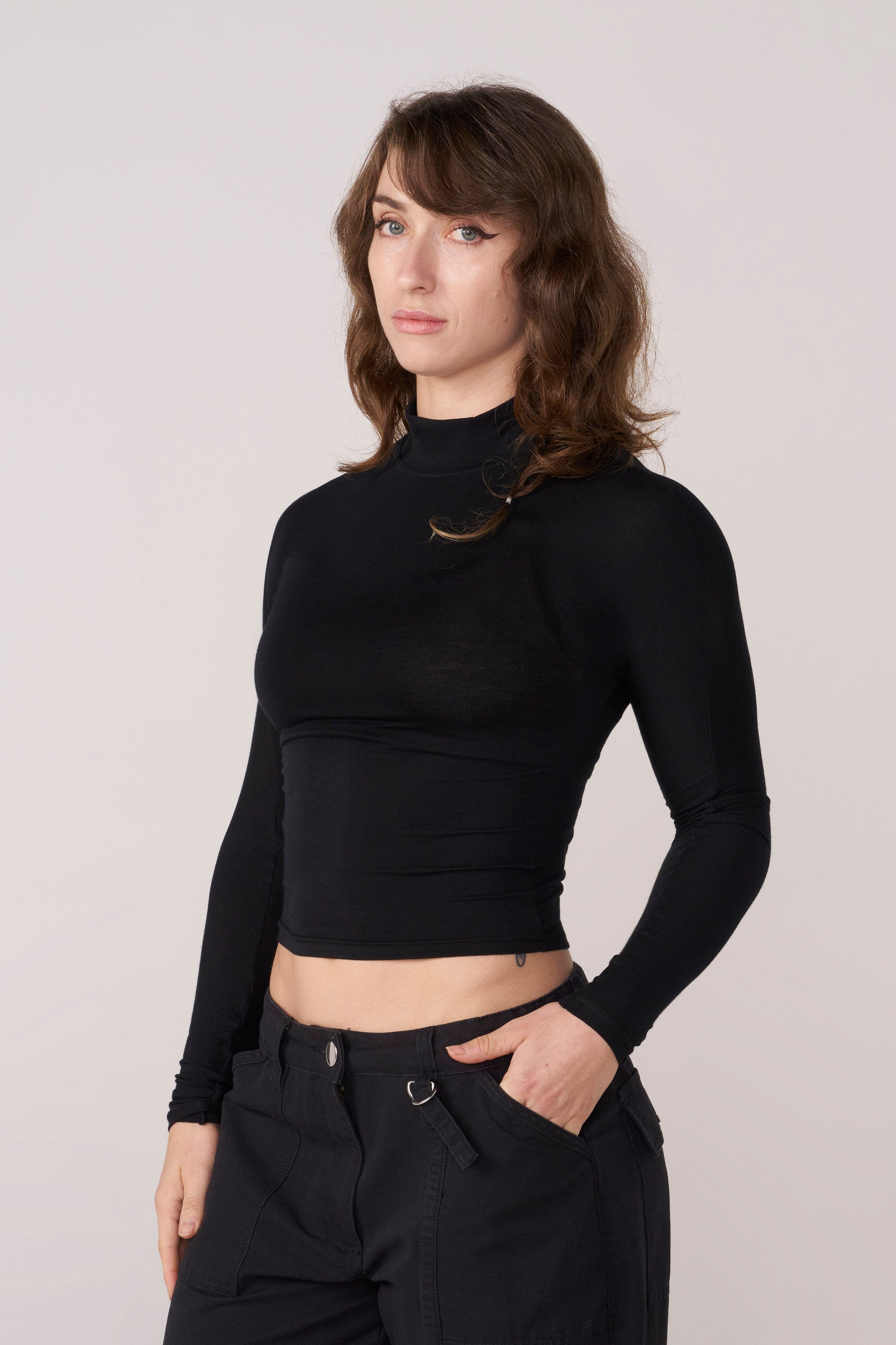 Front view of the sleek sheer long sleeve crop top on a model.