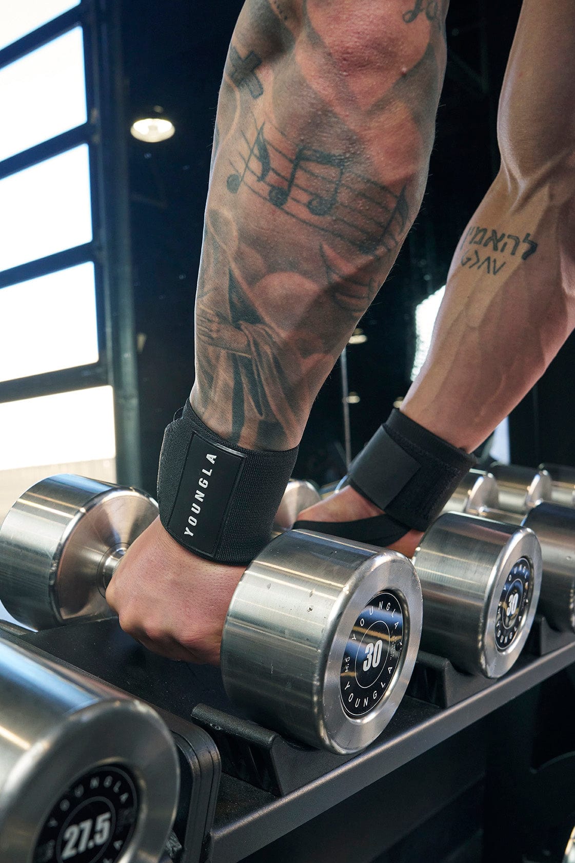 Side angle showing wrist wraps weight training with full tension under strain.