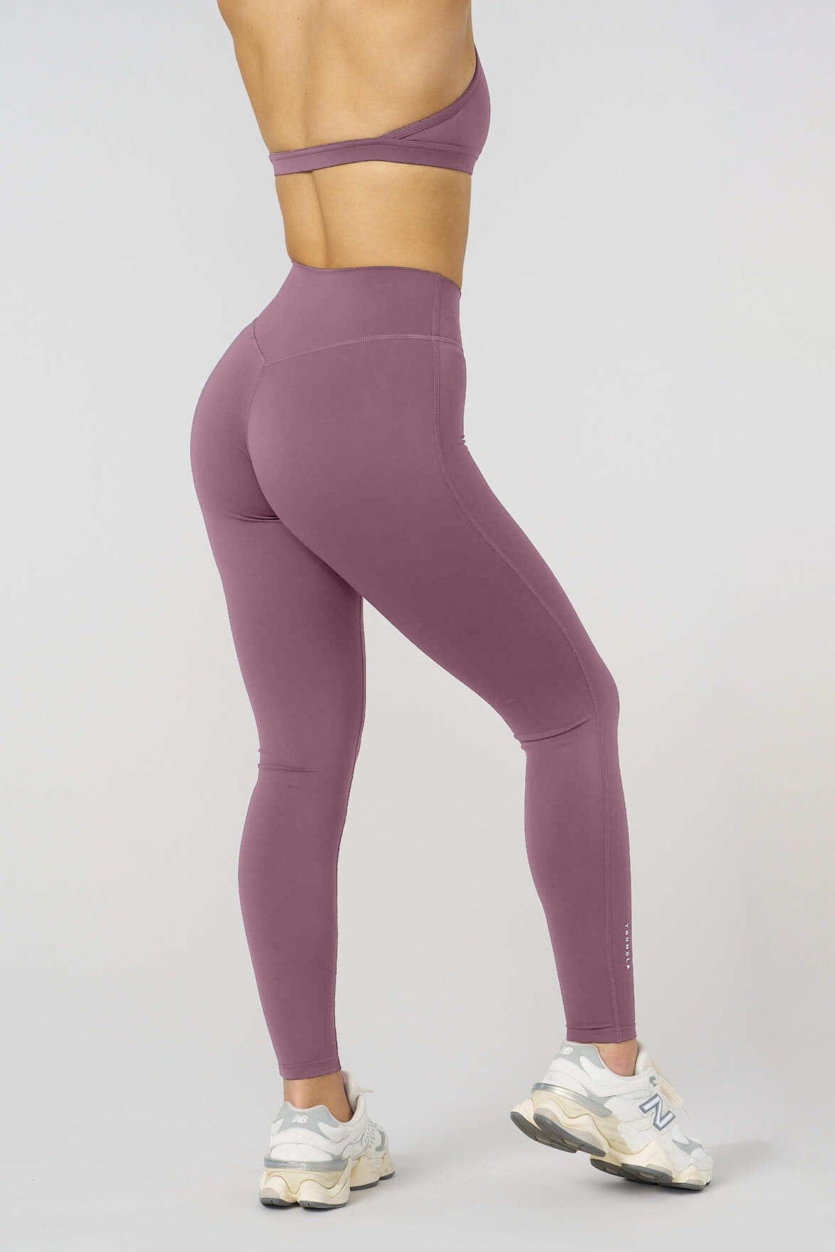 Full-body front view of high rise leggings styled with a cropped workout top