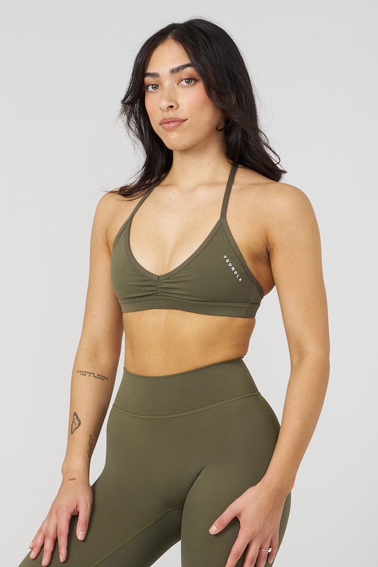Model wearing Urban V-Neck activewear bra while stretching.