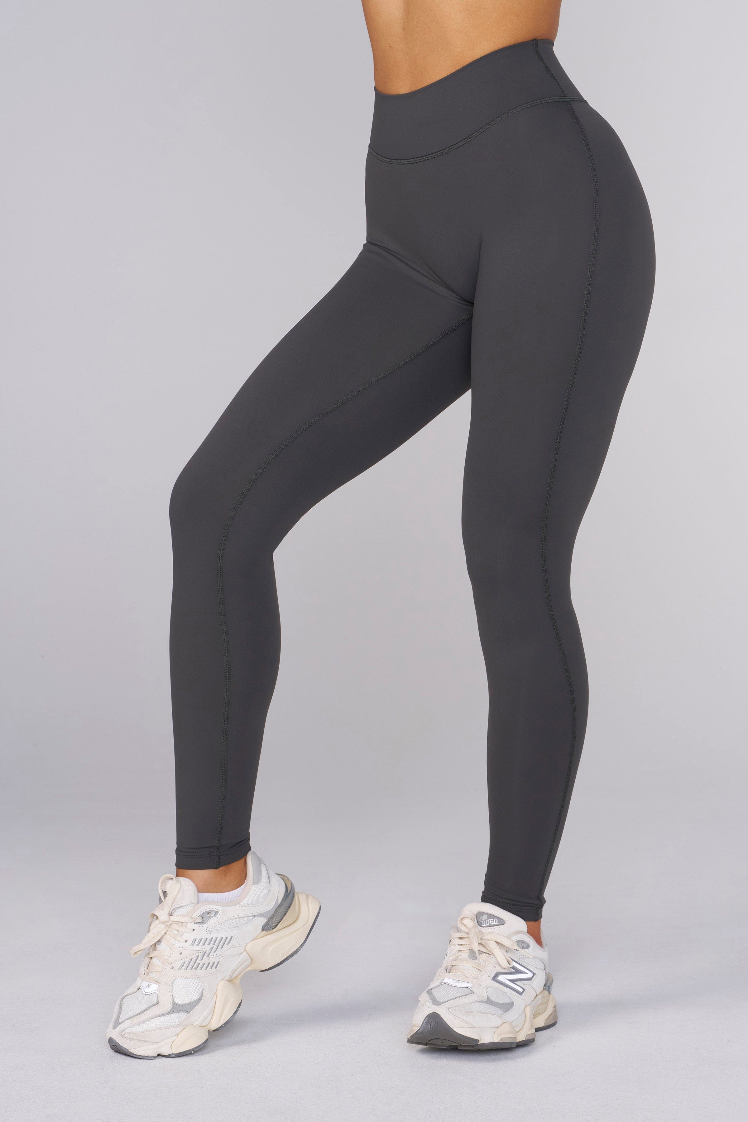 Full-body front view of high rise leggings styled with a cropped workout top