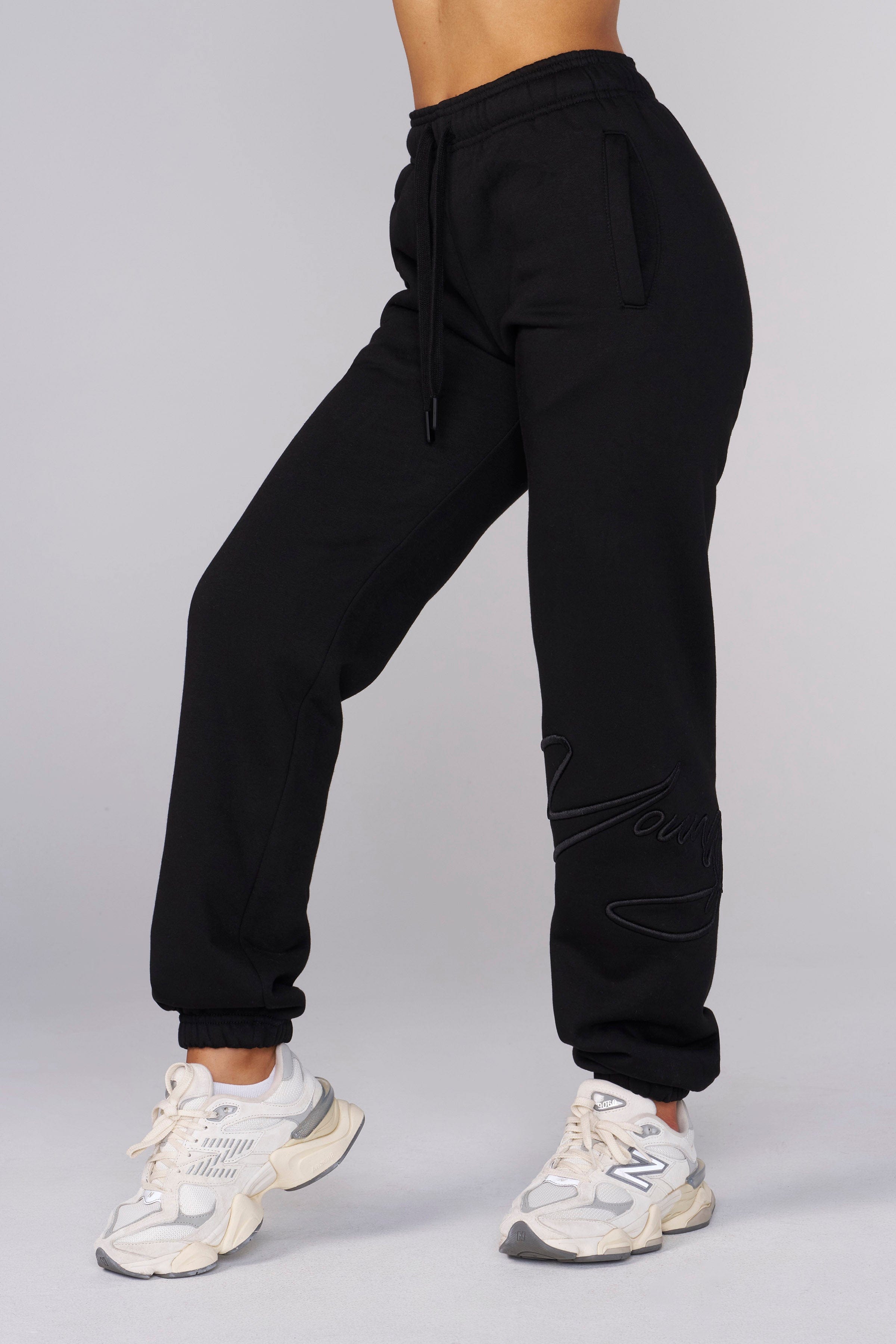 Close-up of fleece joggers with raised embroidery detail.