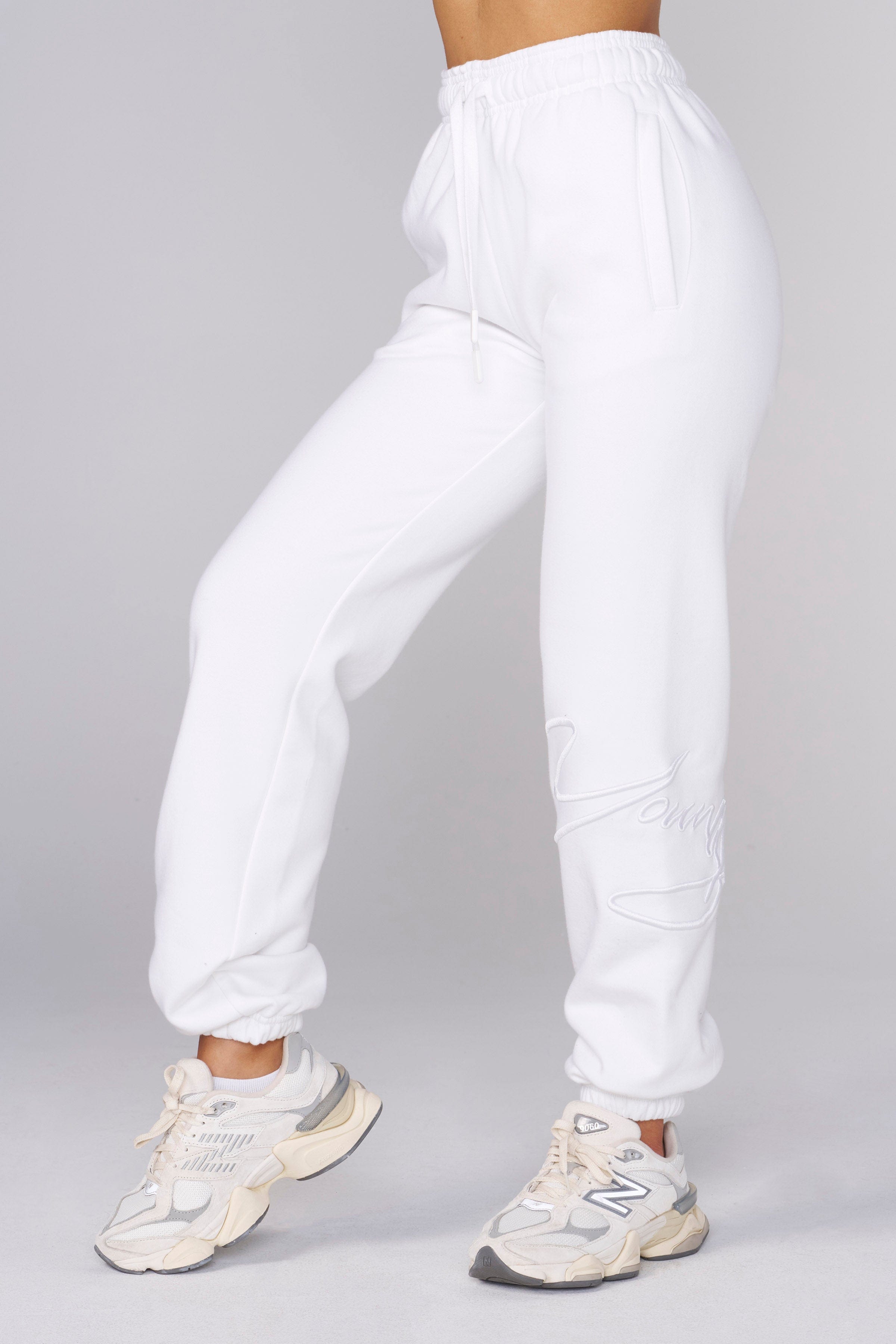 Close-up of fleece joggers with raised embroidery detail.