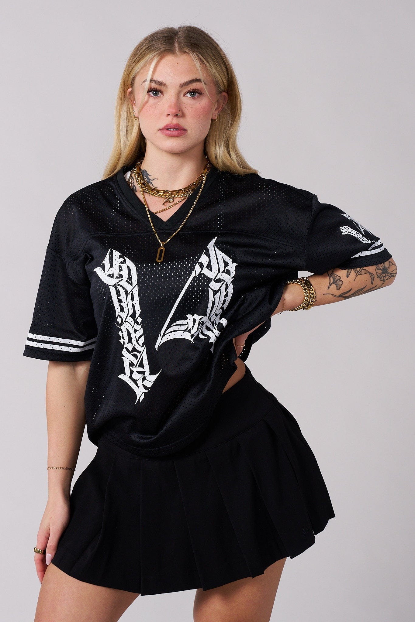 Side profile showing smooth waistband and relaxed pleat movement in black mini skirt