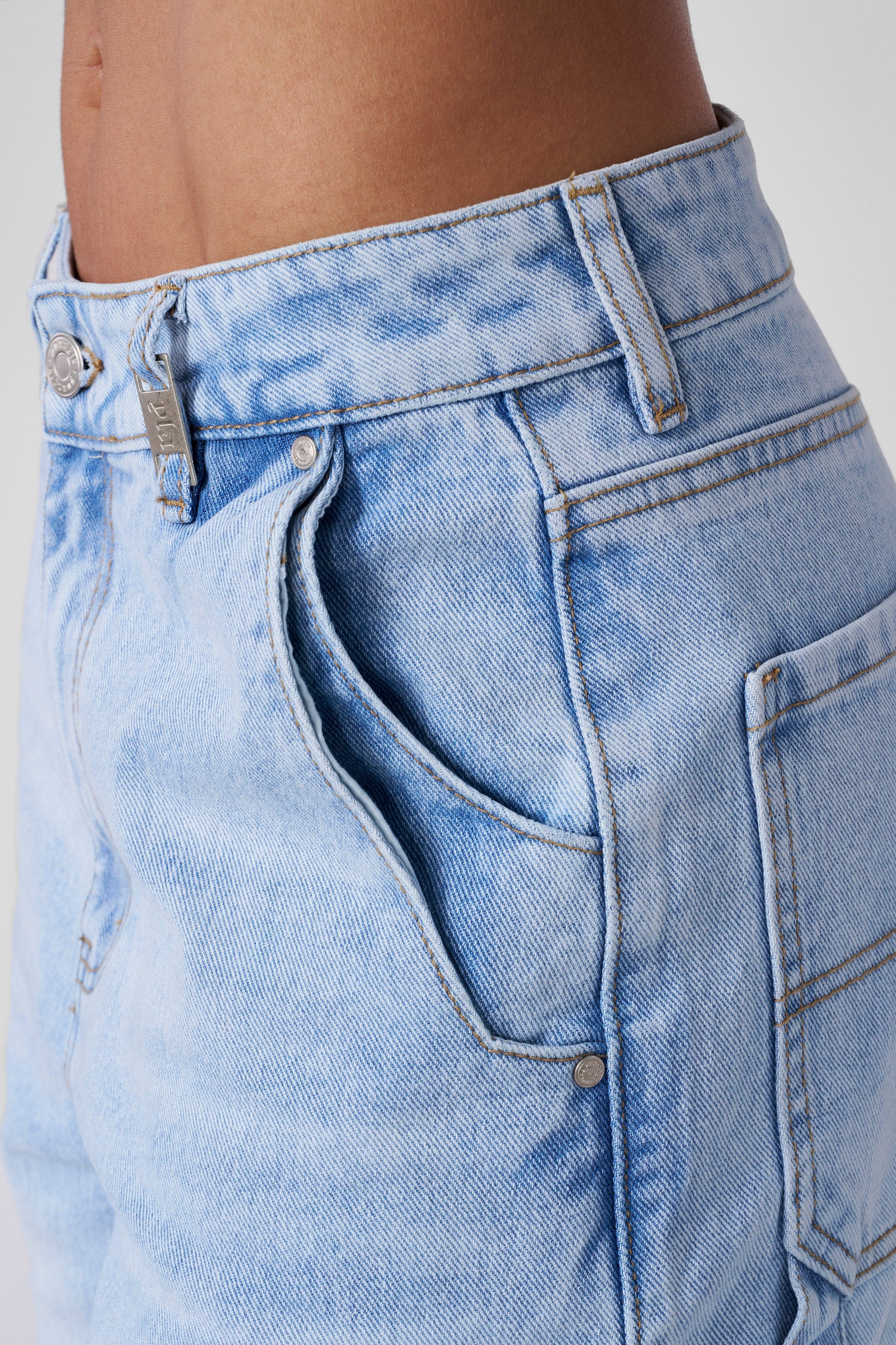 Laid flat light blue denim jean shorts mens on rustic wood surface showcasing relaxed cut.