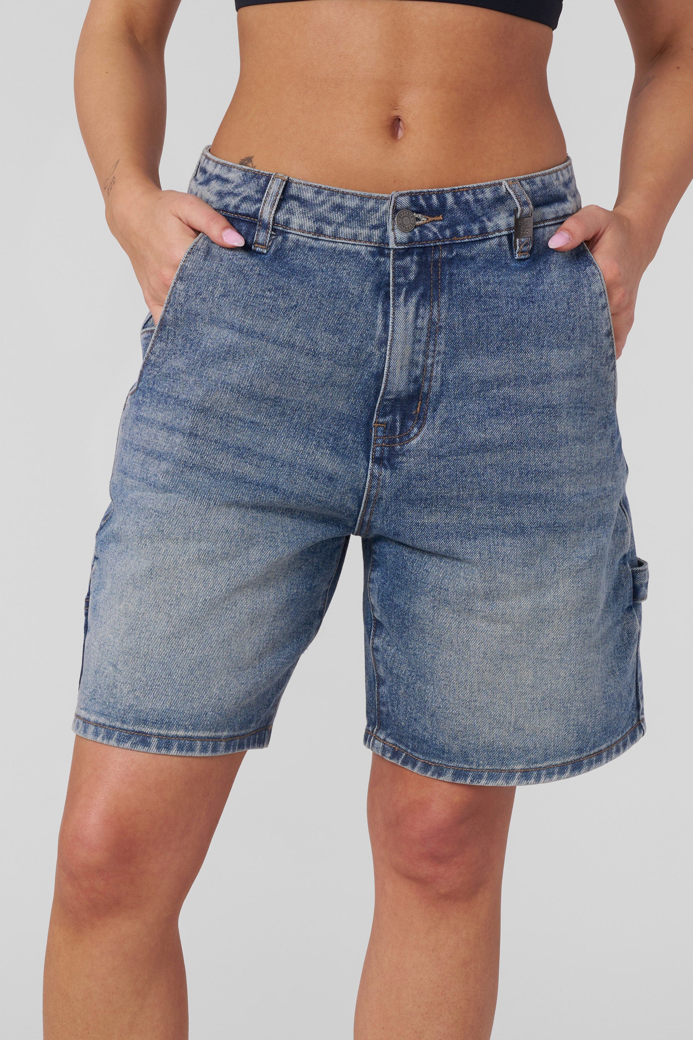Model wearing mens denim shorts while walking through downtown Nashville.