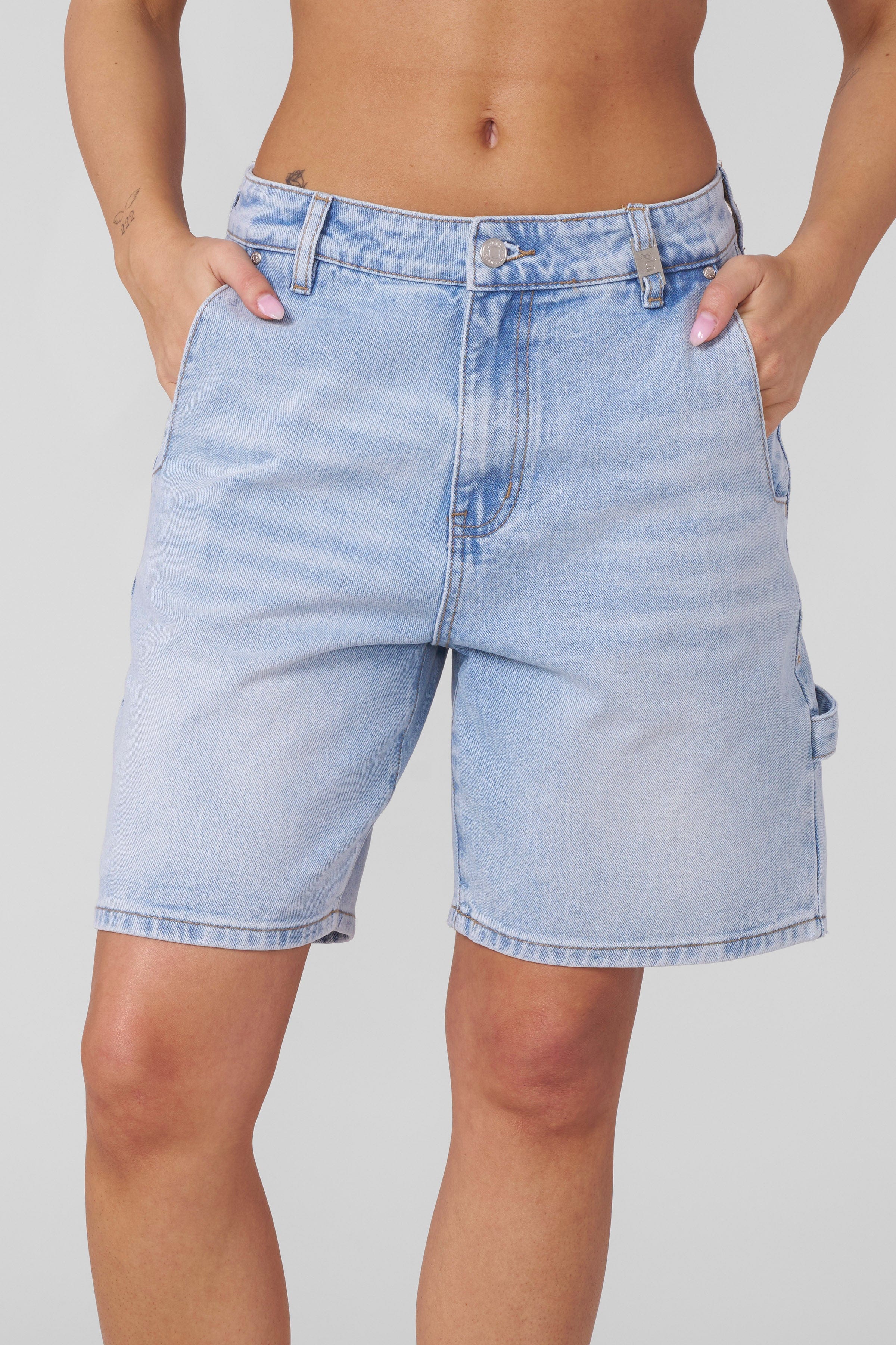 Model wearing mens denim shorts while walking through downtown Nashville.