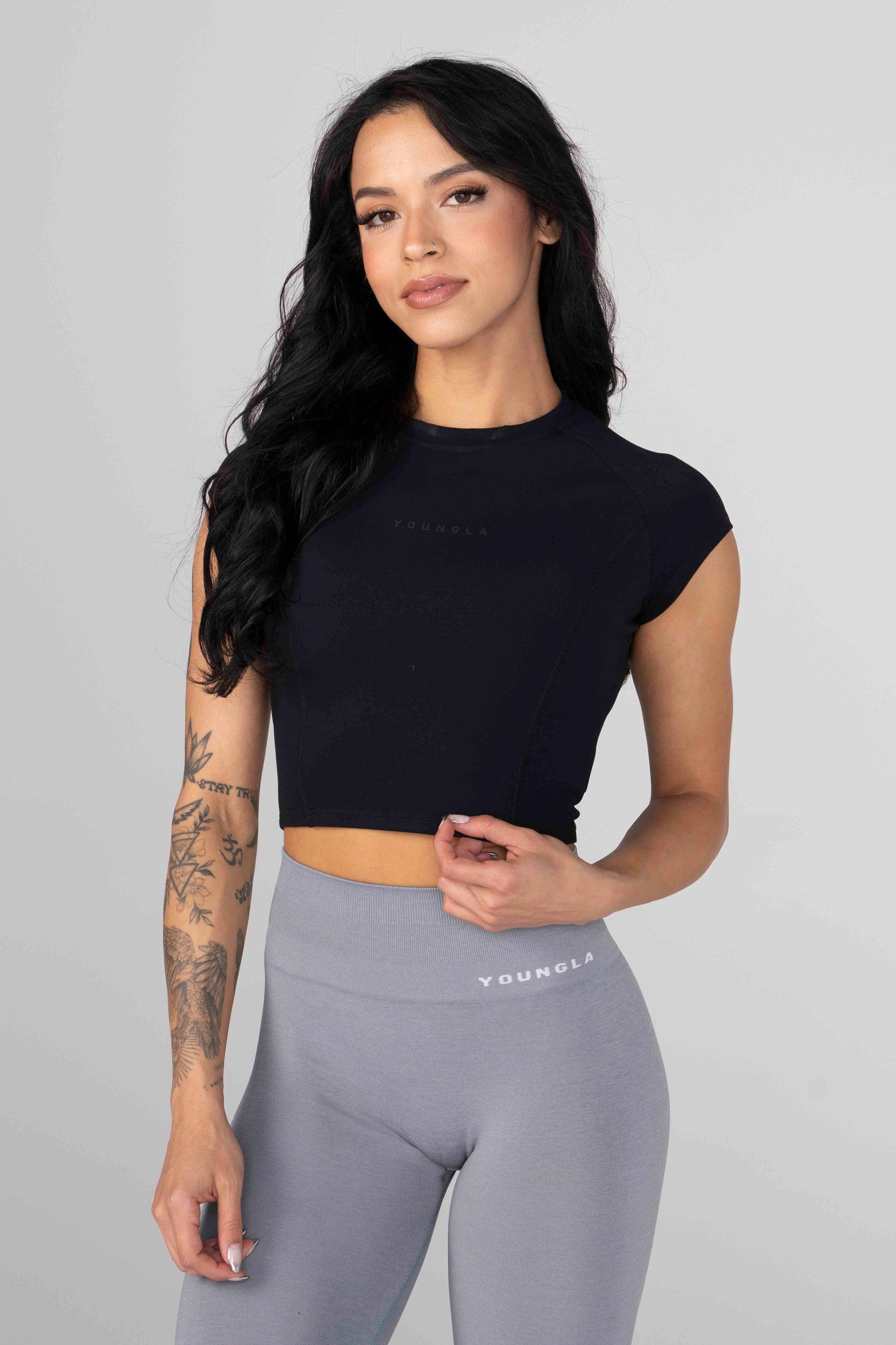 Model wearing Elevate Compression Crop Top while lifting weights.