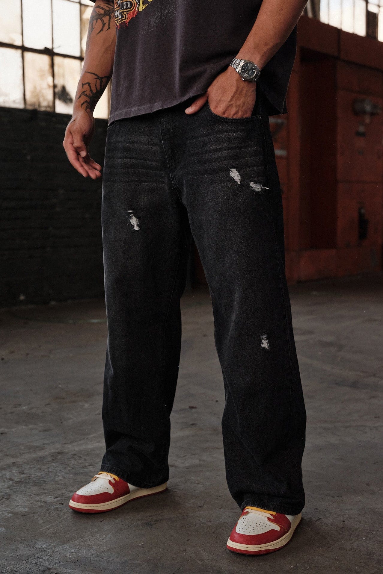 Close-up of distressed detailing on mens loose jeans
