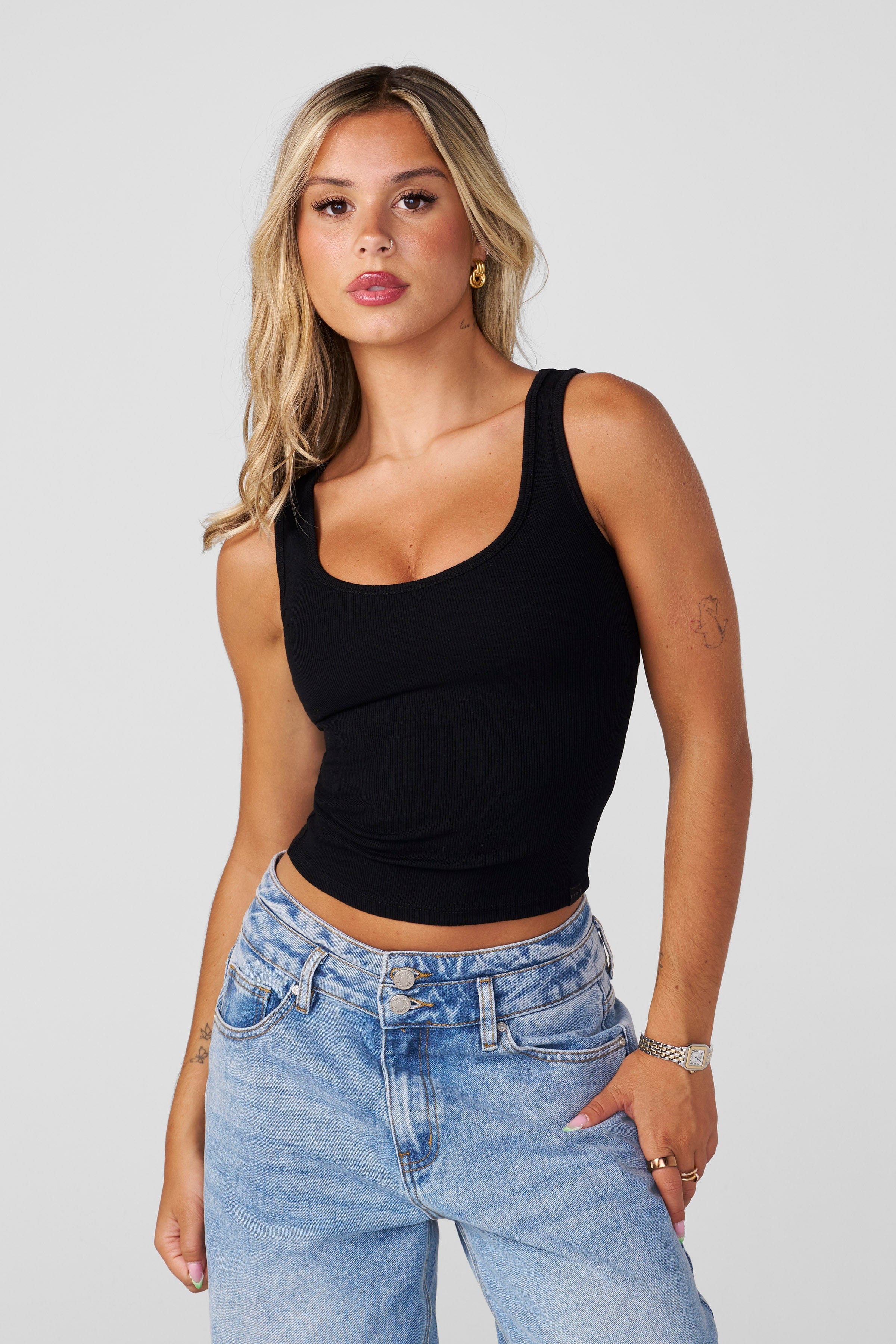 Front view of cropped tank top men’s version styled with joggers