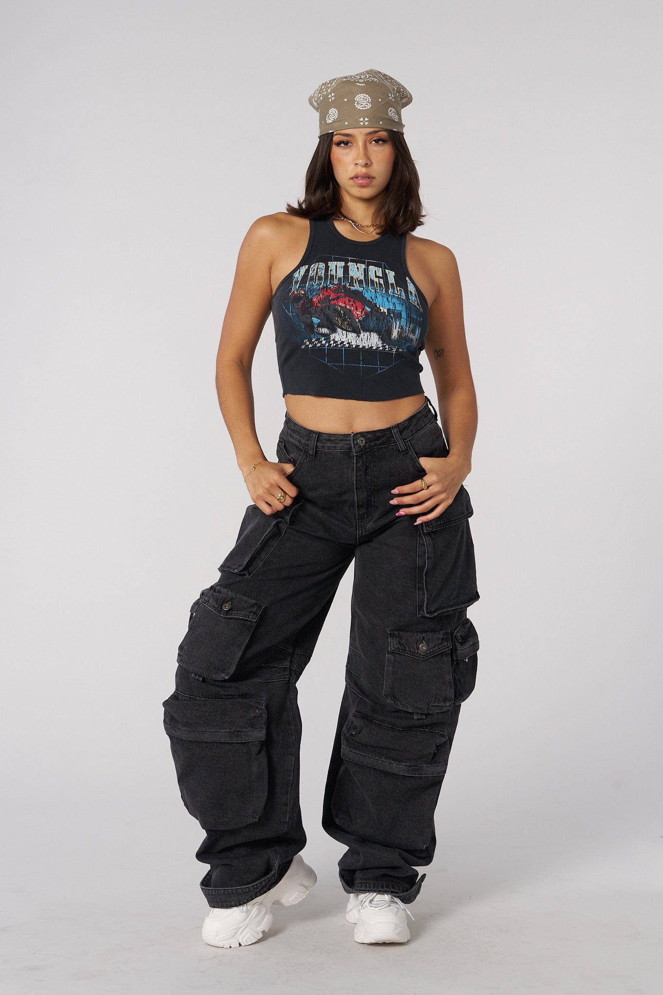 Model wearing a graphic tank top paired with cargo jeans, embodying modern streetwear style.