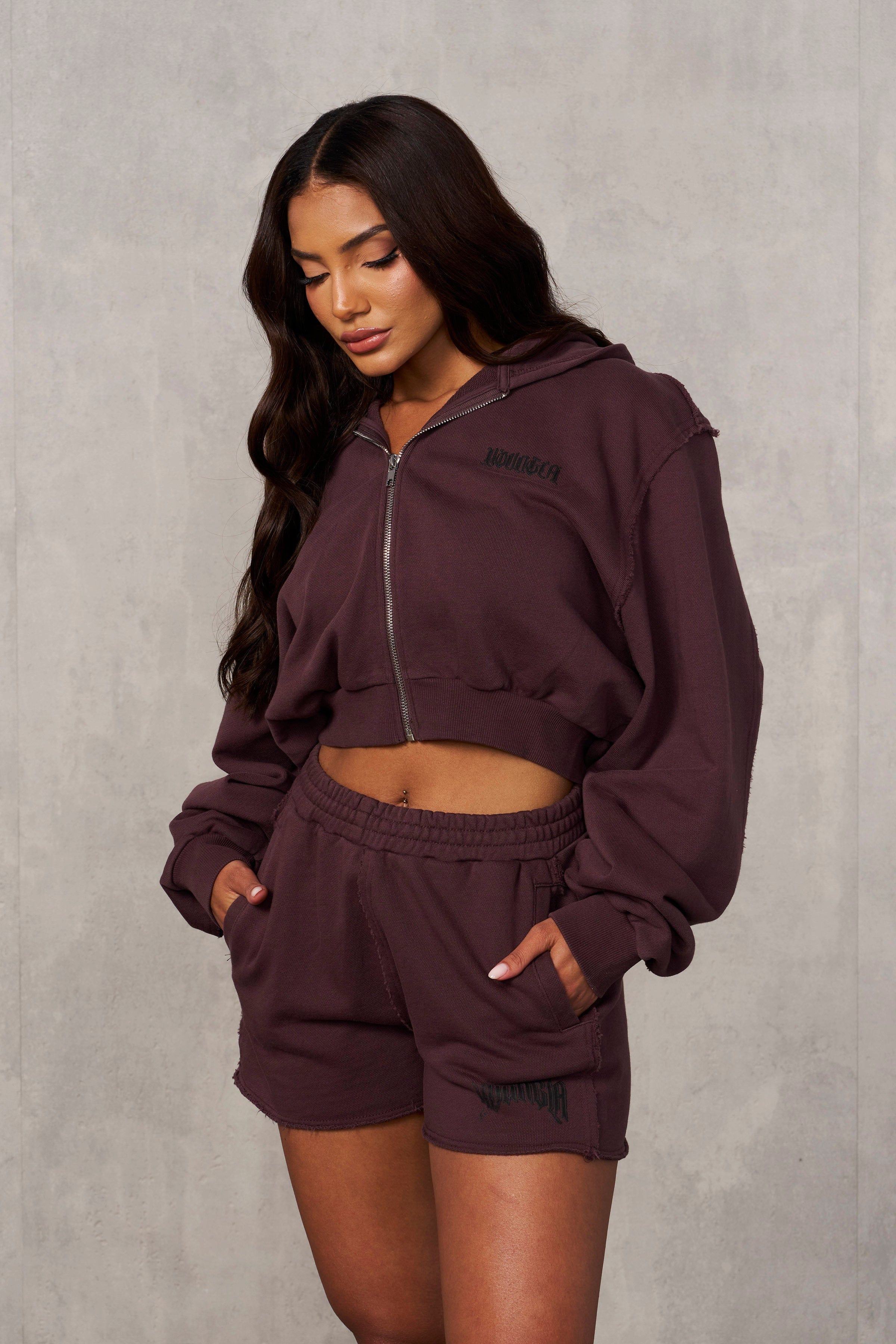 Mens black cropped hoodie styled with ripped jeans for urban grunge look