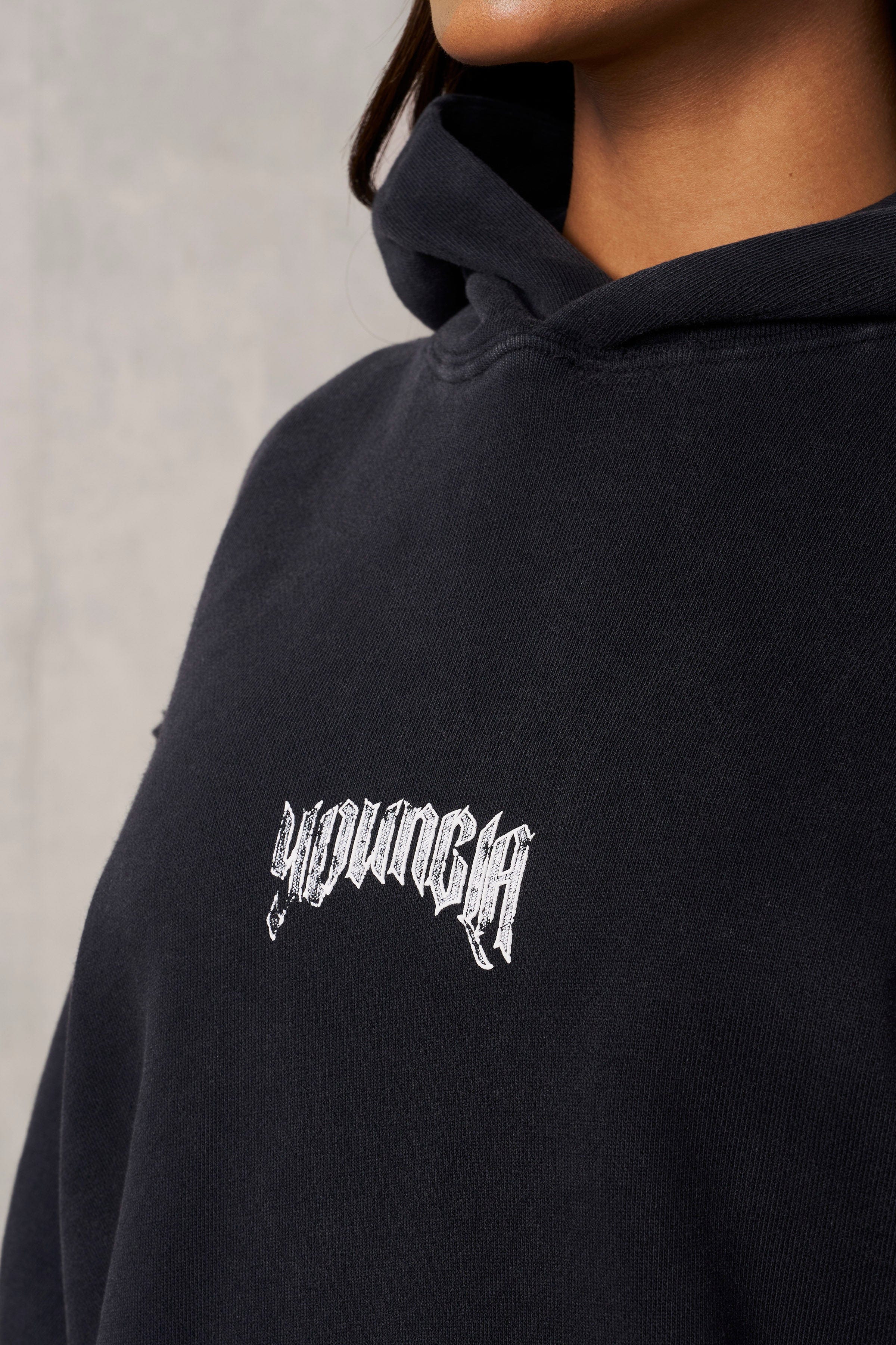 Streetwear outfit pairing the hoodie with black jeans and sneakers
