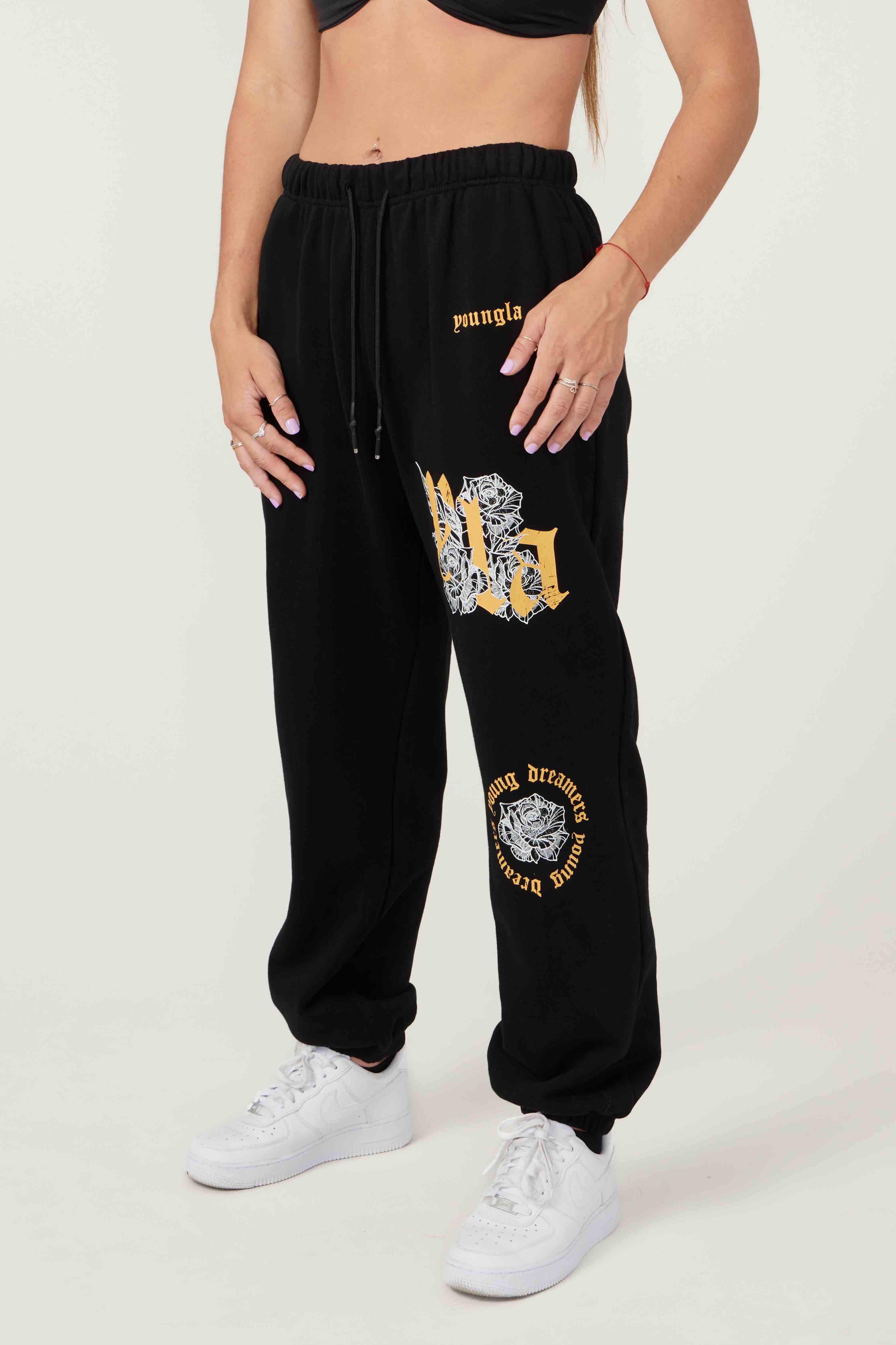 YLA rose floral joggers front view, model styling relaxed-fit black joggers