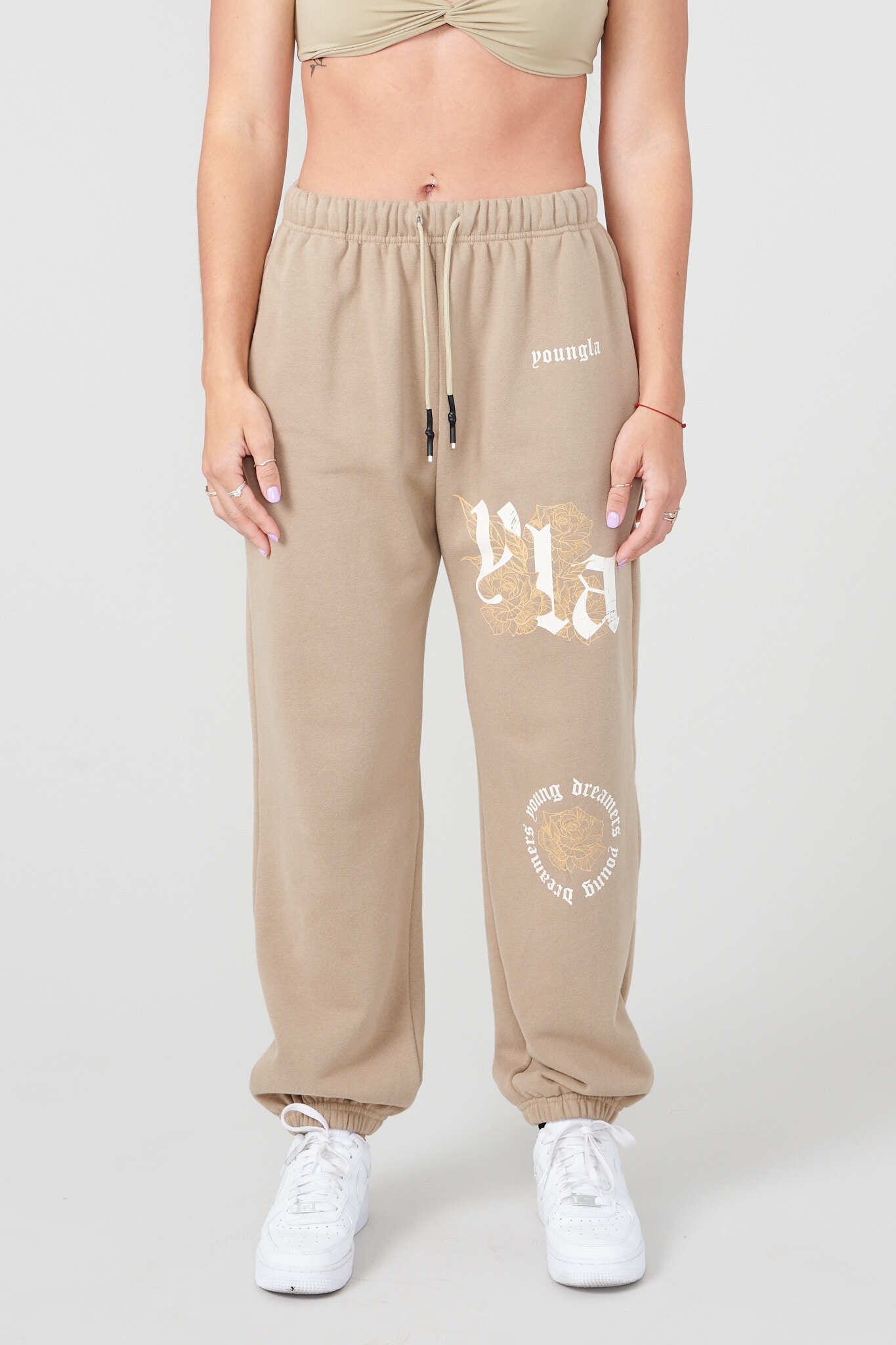 YLA rose floral joggers front view, model styling relaxed-fit black joggers