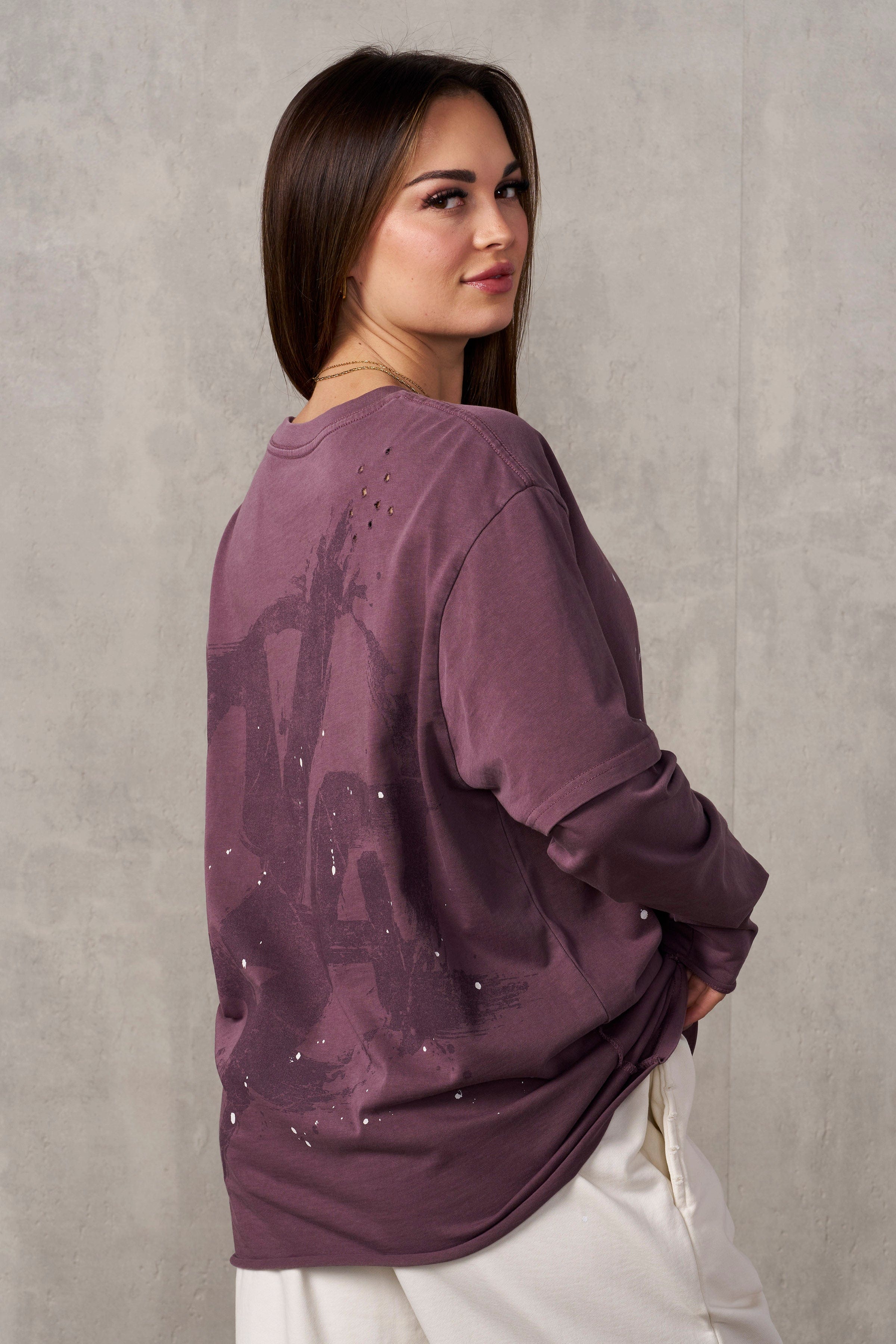Close-up of rips and paint splatter on oversized grunge tee.