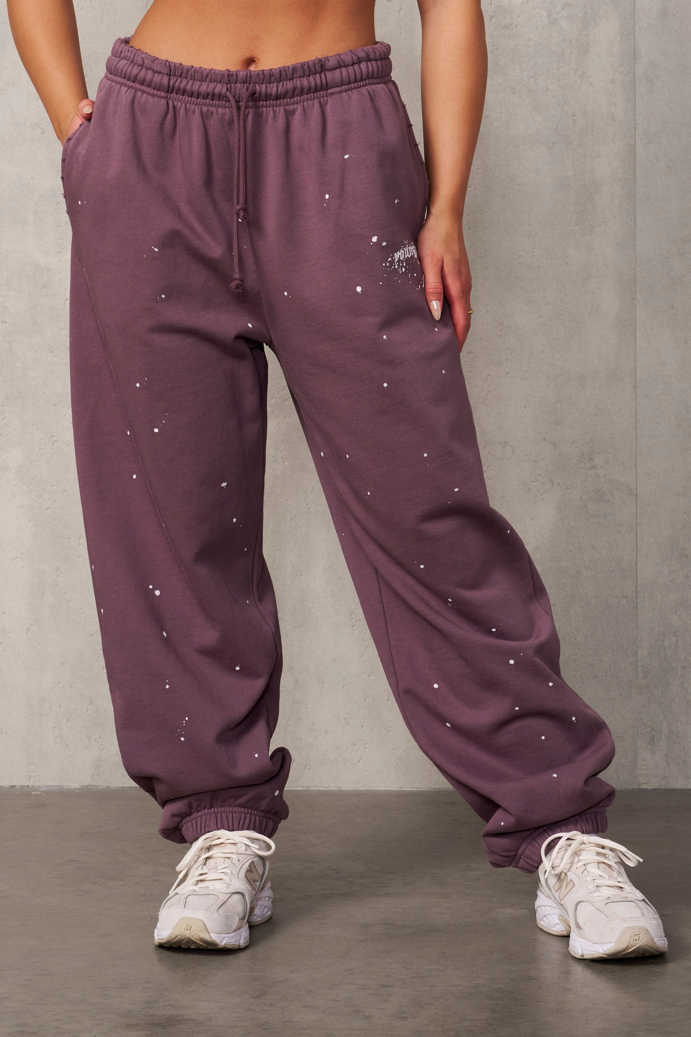Close-up detail of the paint-splatter and distressed pockets on these oversized pants for men.