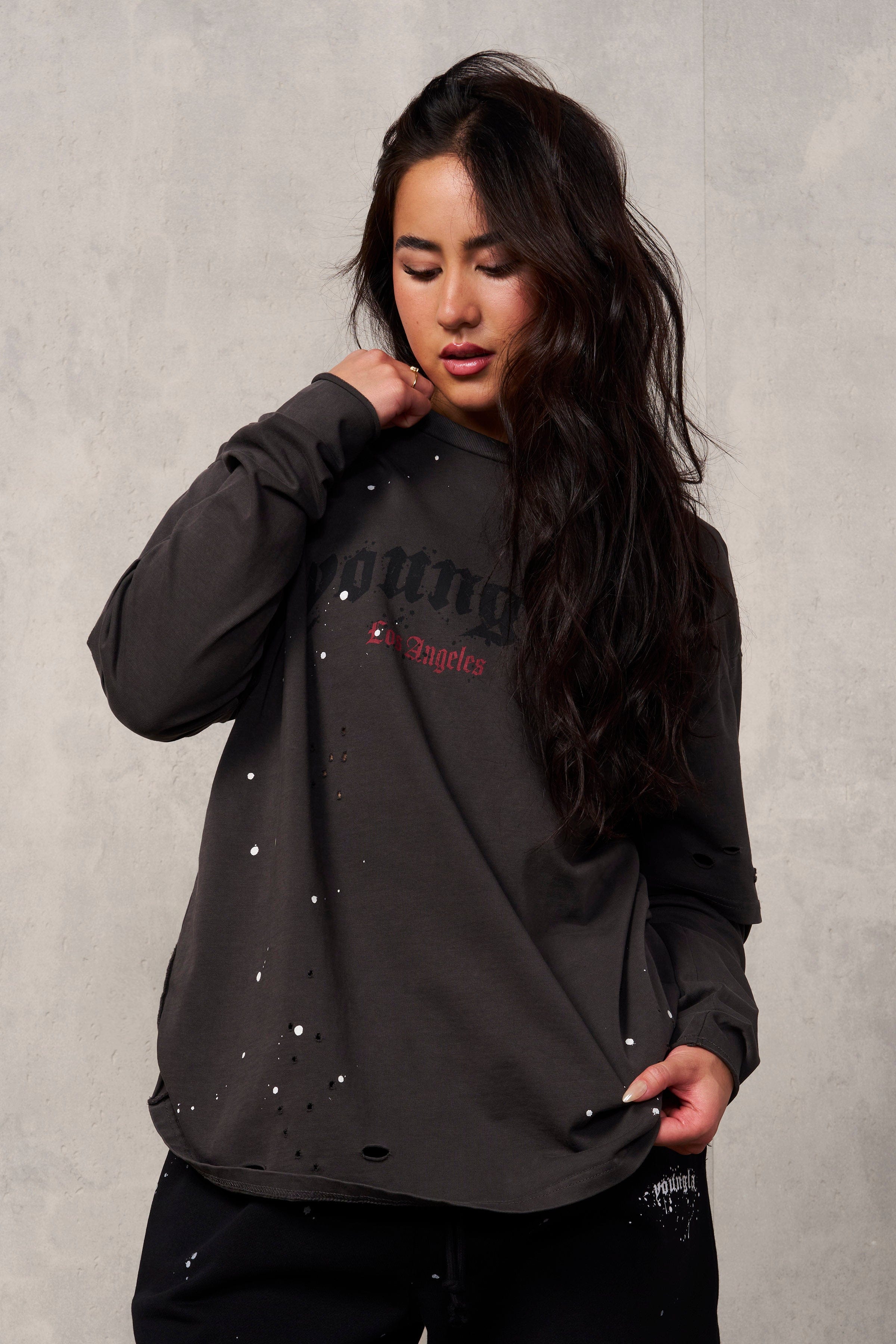 Close-up of rips and paint splatter on oversized grunge tee.