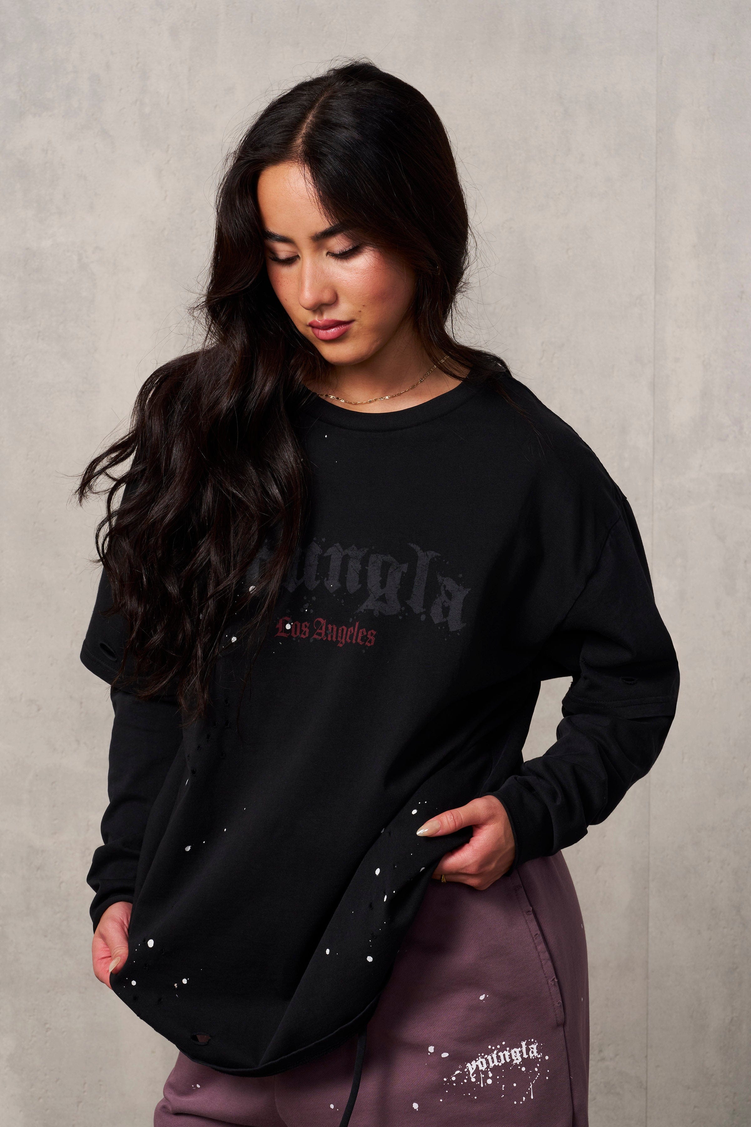 Close-up of rips and paint splatter on oversized grunge tee.