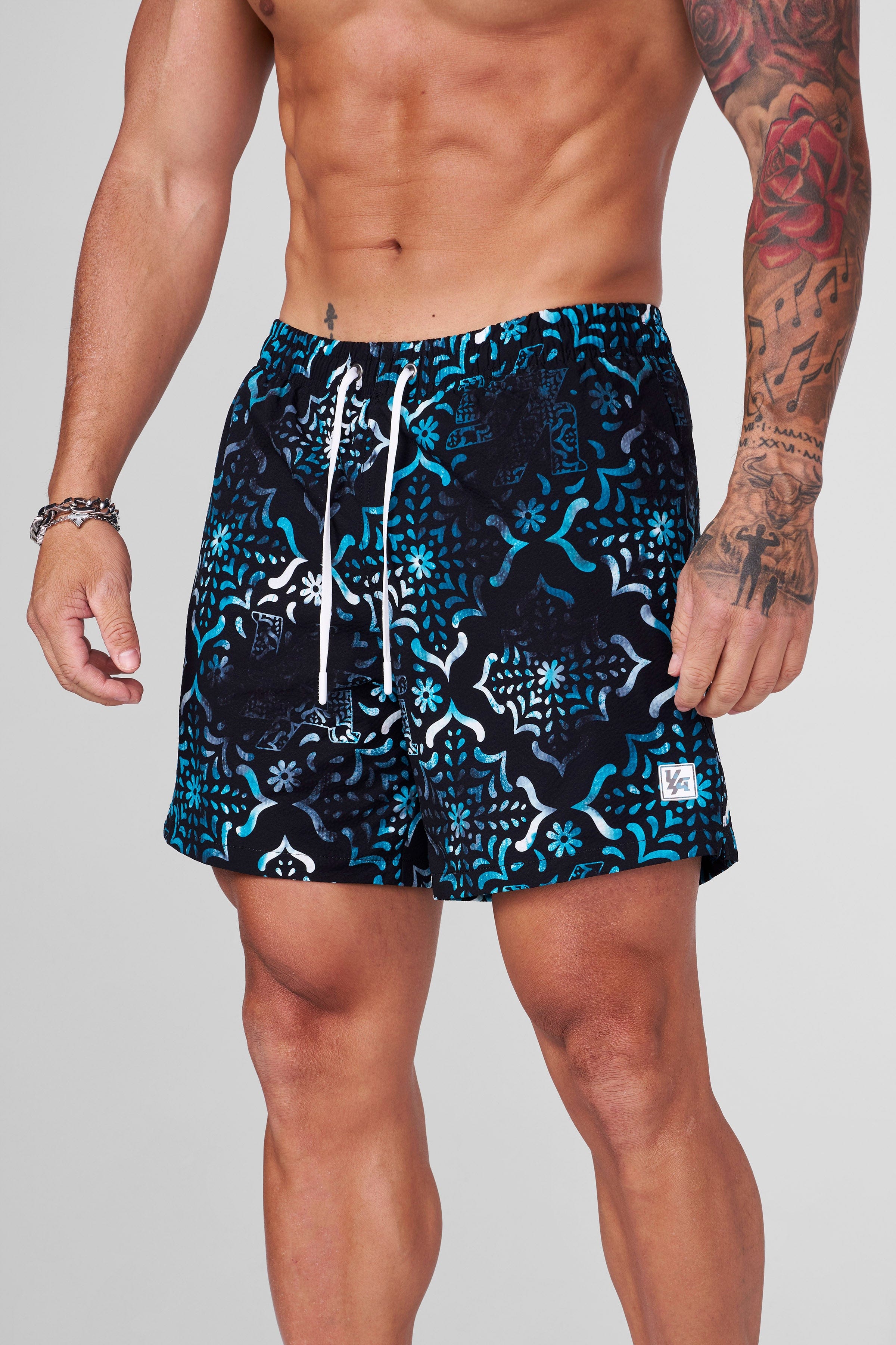 Folded polyester swim shorts with mosaic design ready for packing