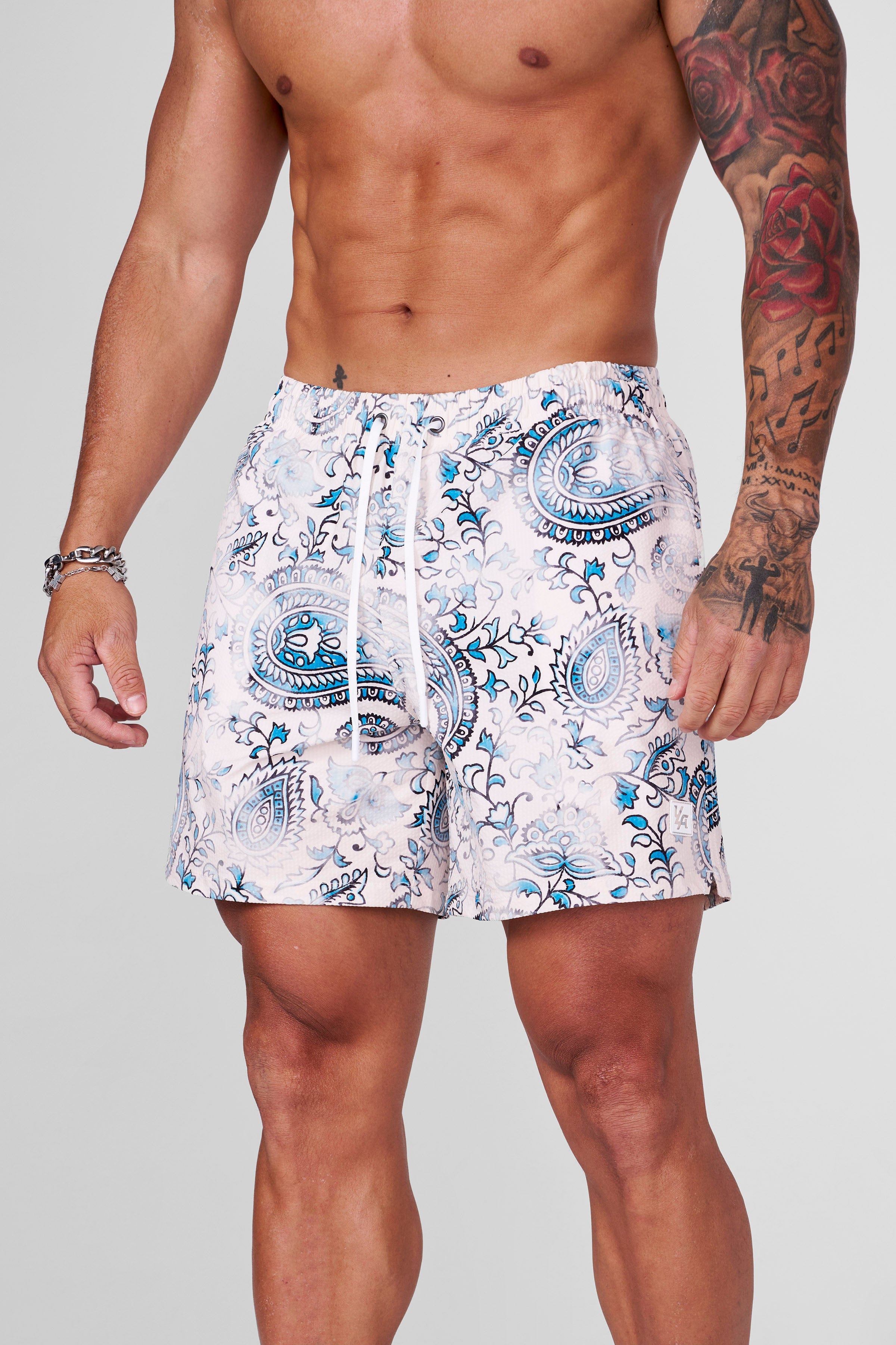 Folded polyester swim shorts with mosaic design ready for packing