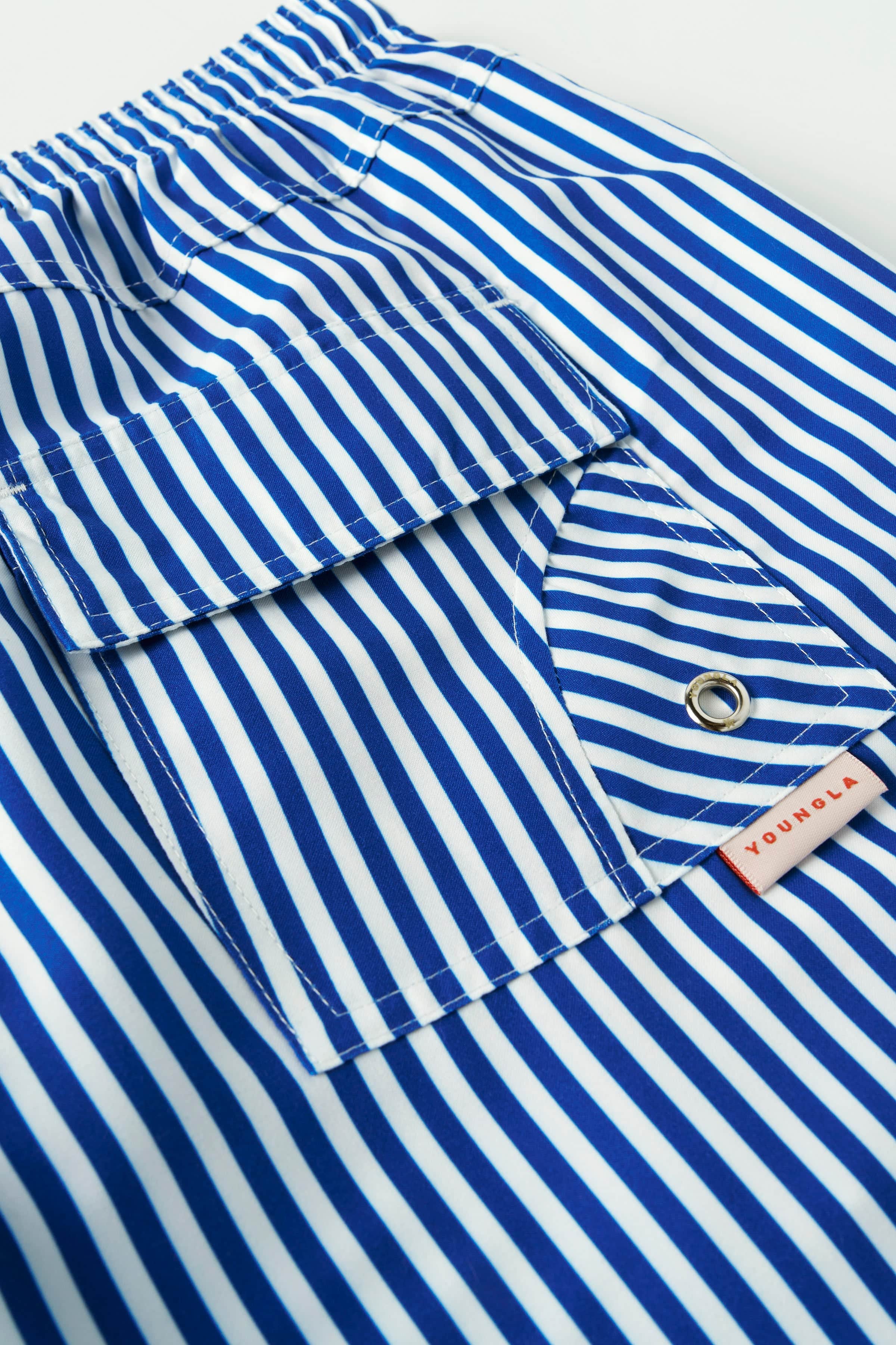 Men wearing striped swim shorts at the poolside, summer style