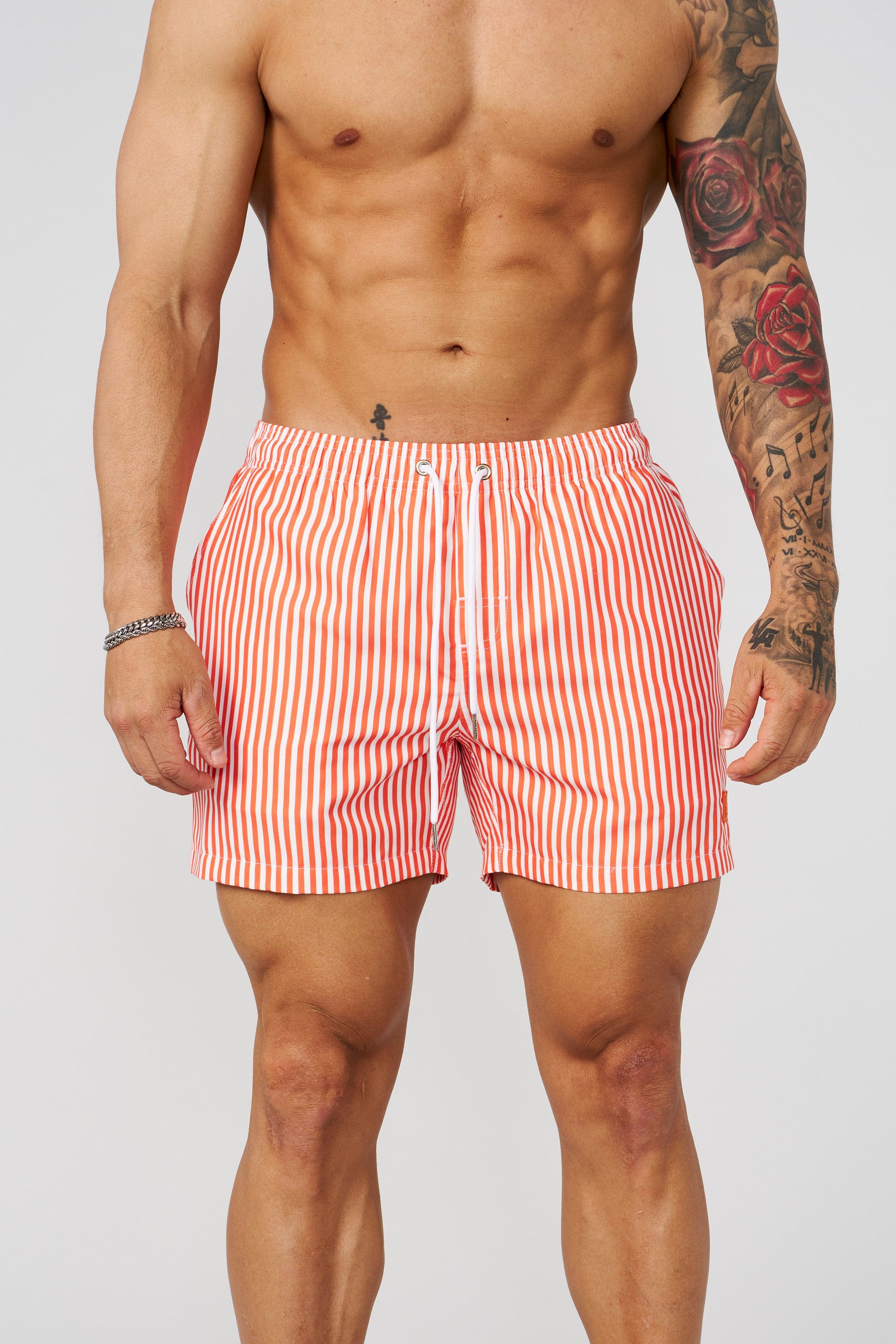 Men wearing striped swim shorts at the poolside, summer style