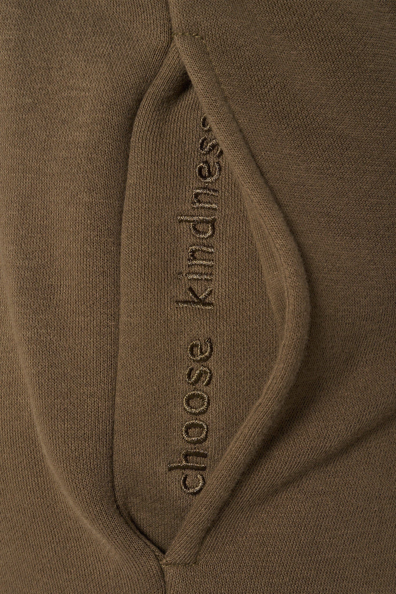 Close-up of hidden quote inside pocket of joggers, adding a personal touch.
