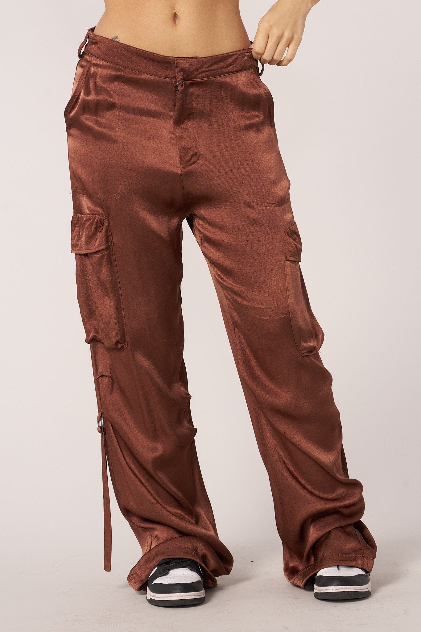 Model wearing black satin cargo pants with a casual white tee