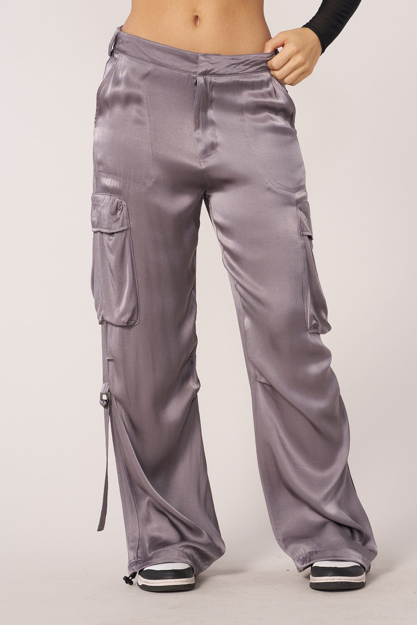 Model wearing black satin cargo pants with a casual white tee