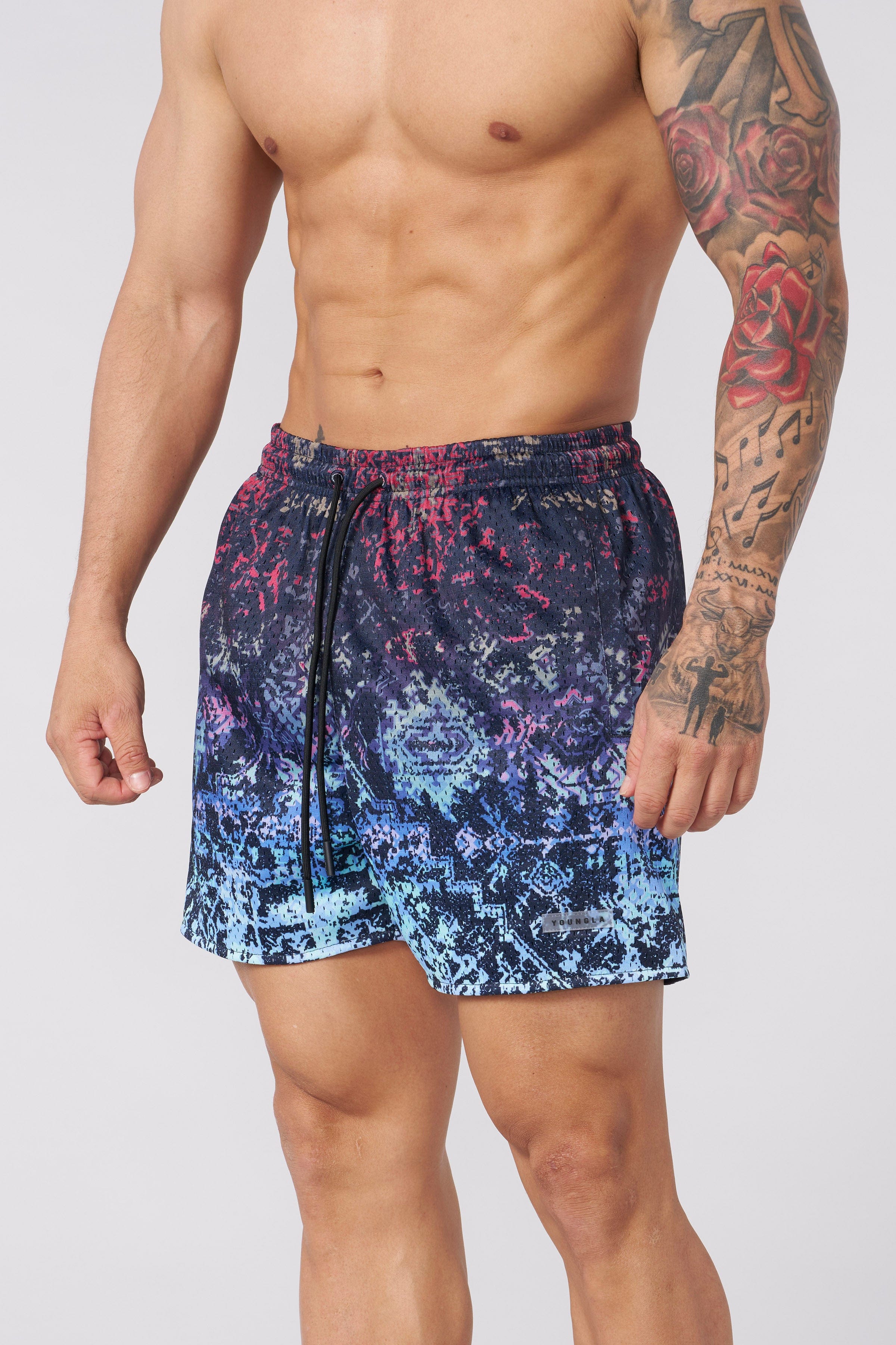 Model wearing camo mesh shorts outdoors during a workout.