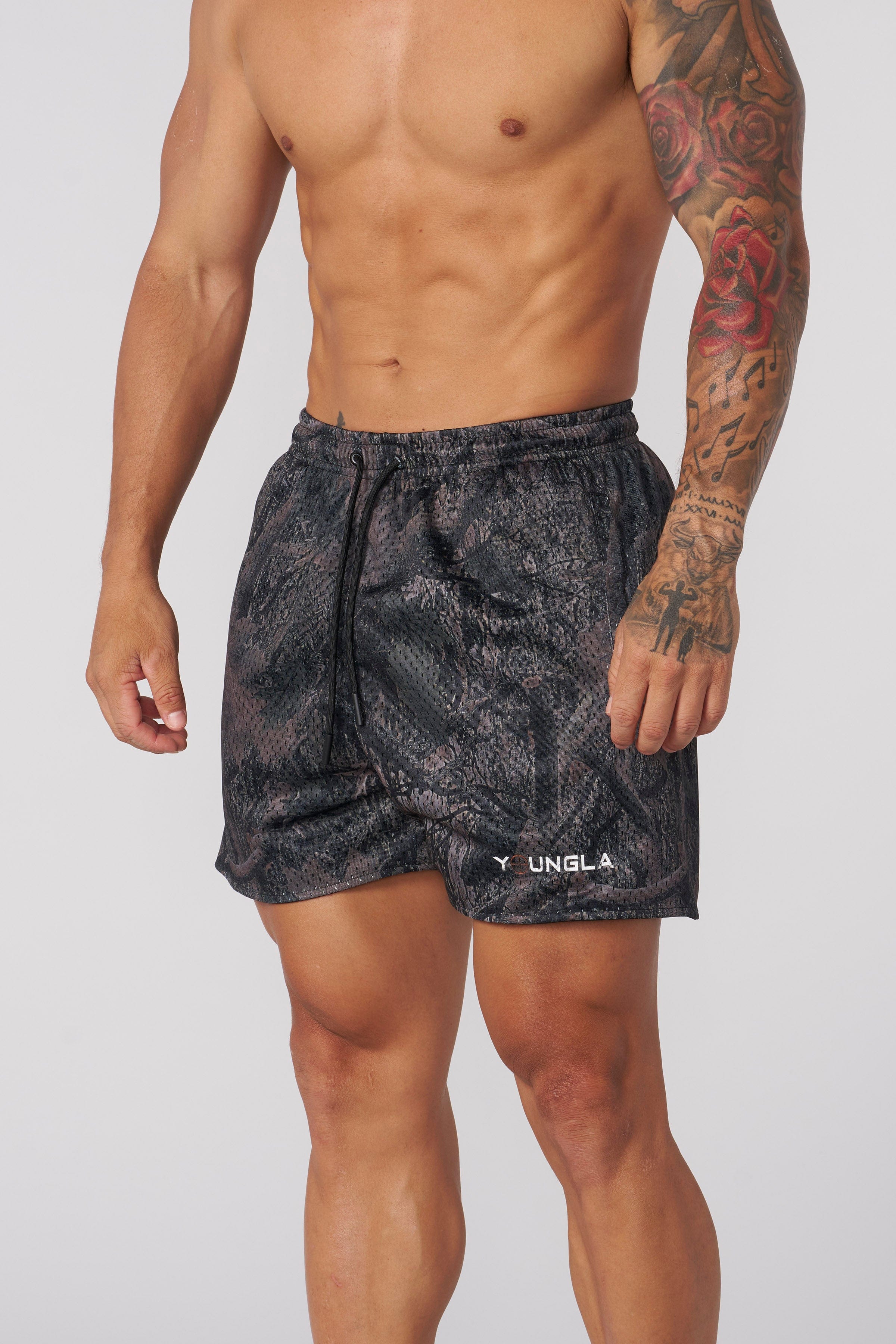 Close-up of men's camo shorts showcasing mesh texture and tree camouflage design