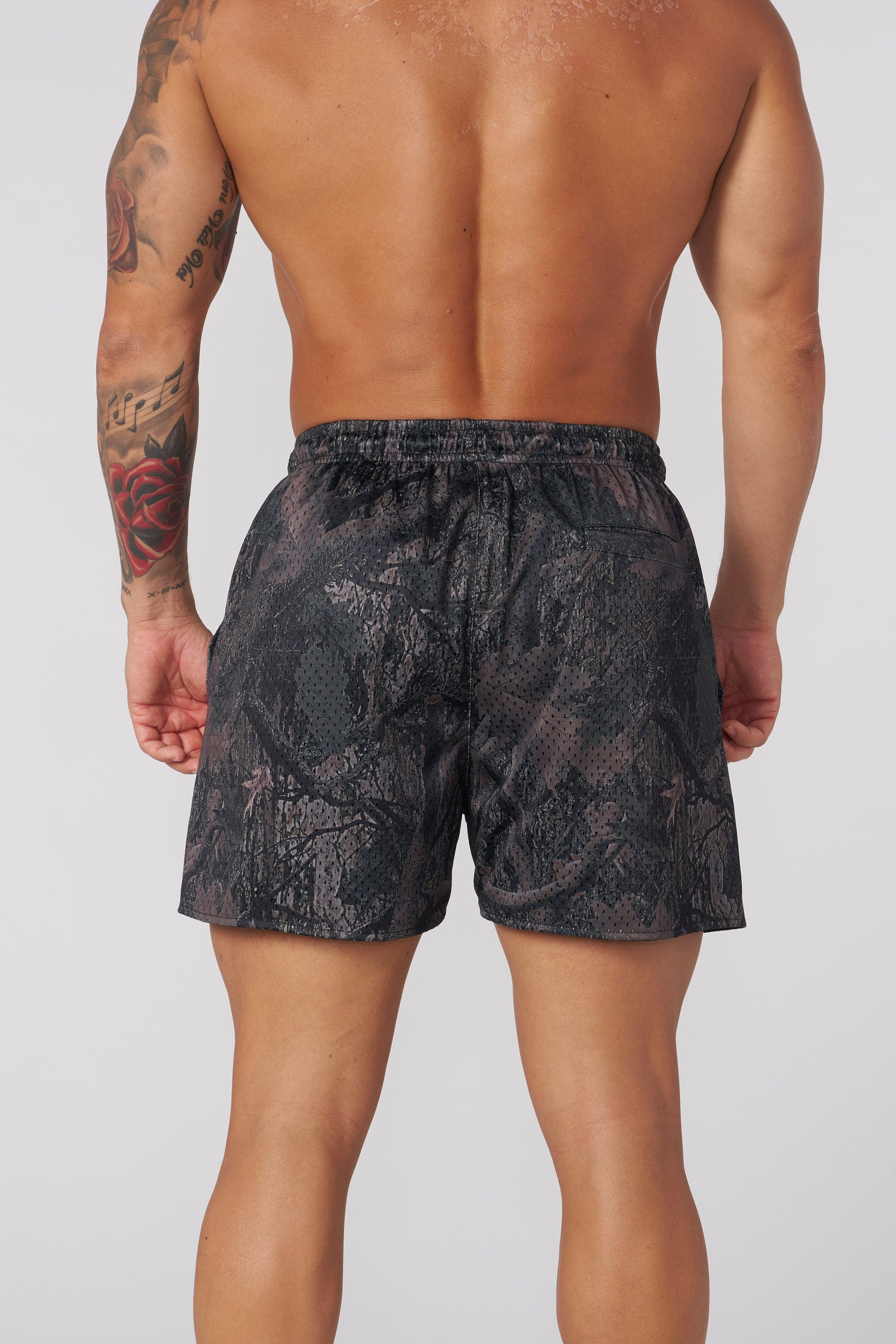 Rear view highlighting the functional pockets and tapered fit of the mesh shorts