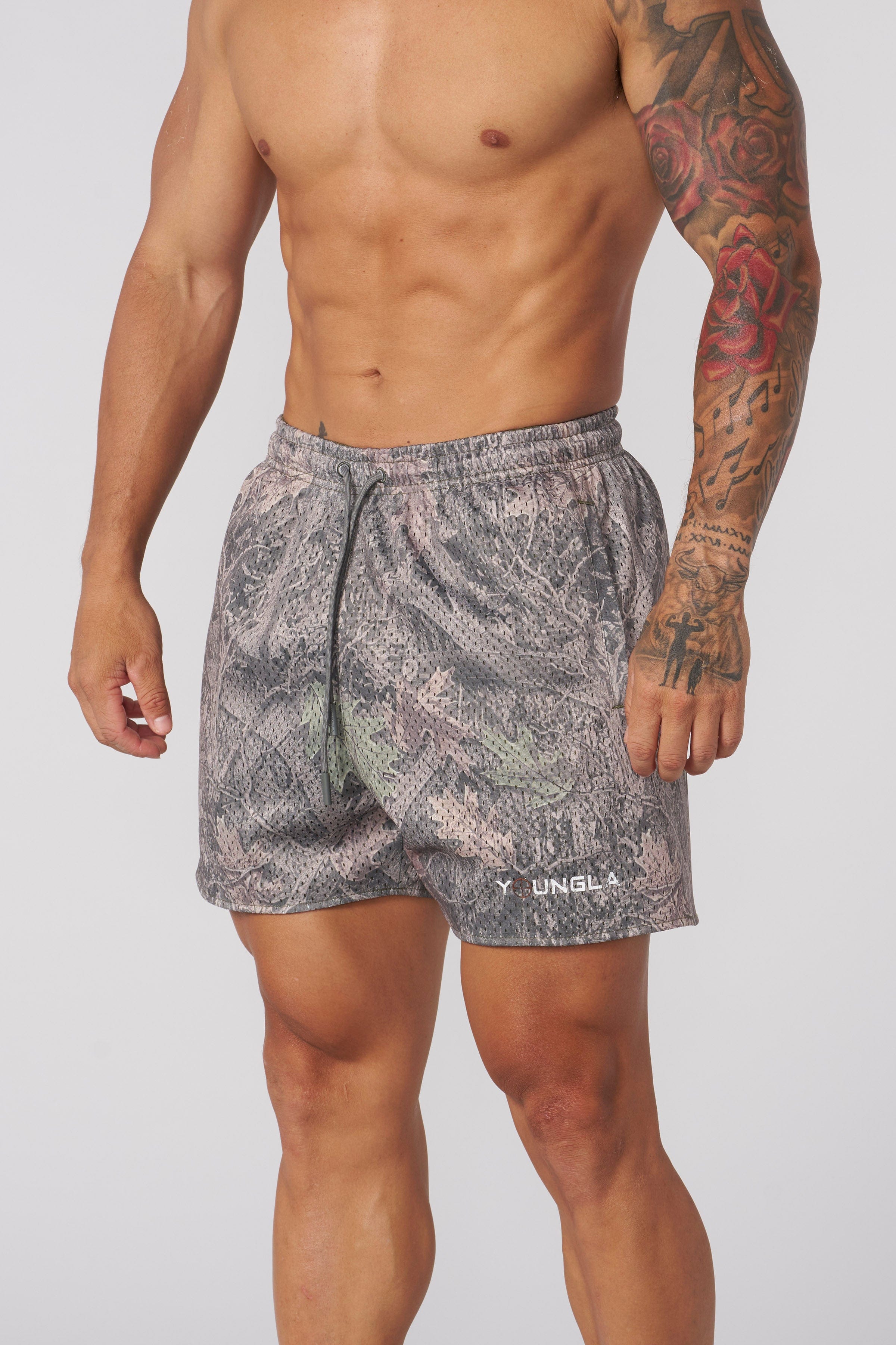 Close-up of mens camo shorts showcasing mesh texture and tree camouflage design