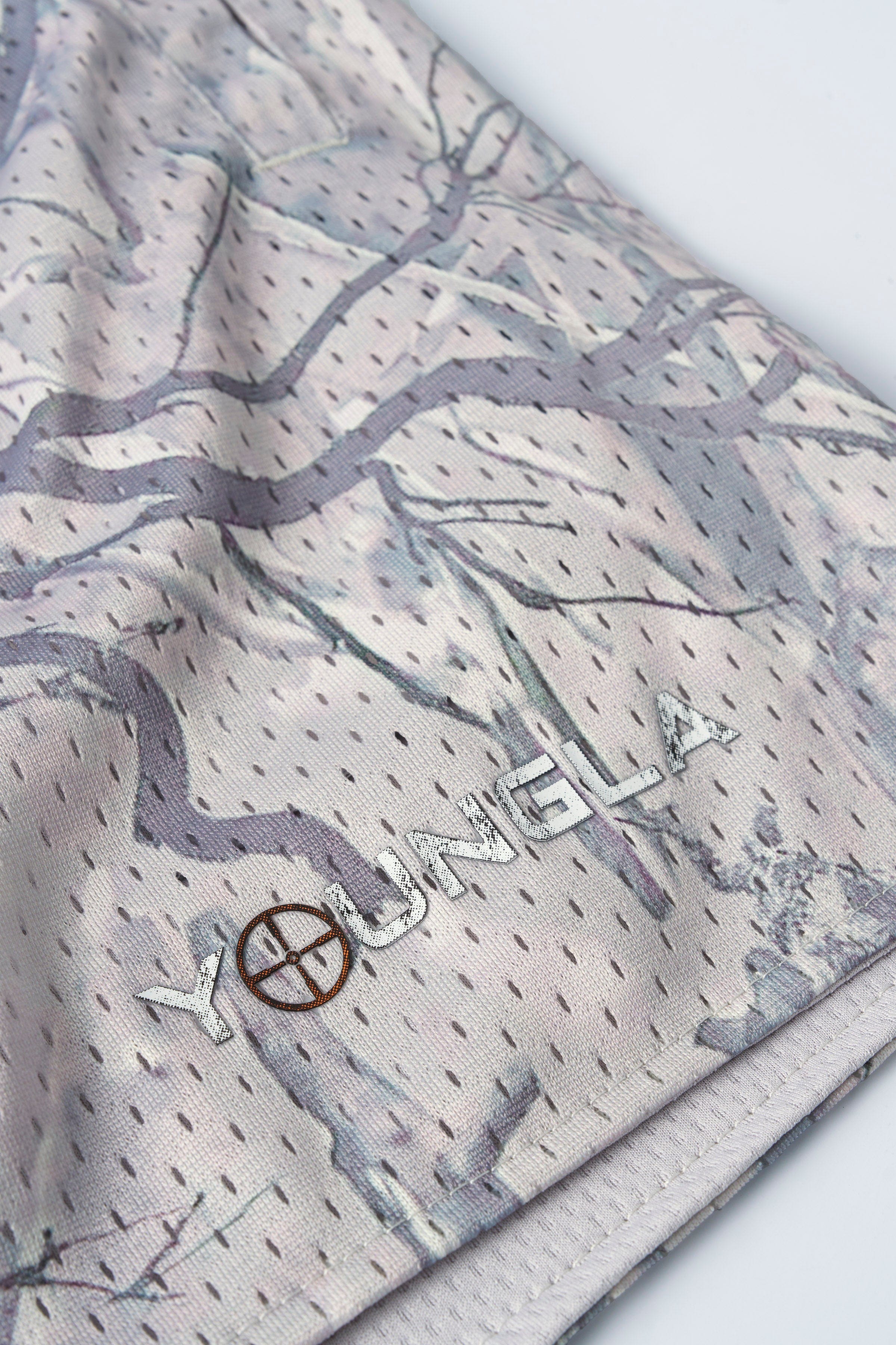 Close-up of mens camo shorts showcasing mesh texture and tree camouflage design