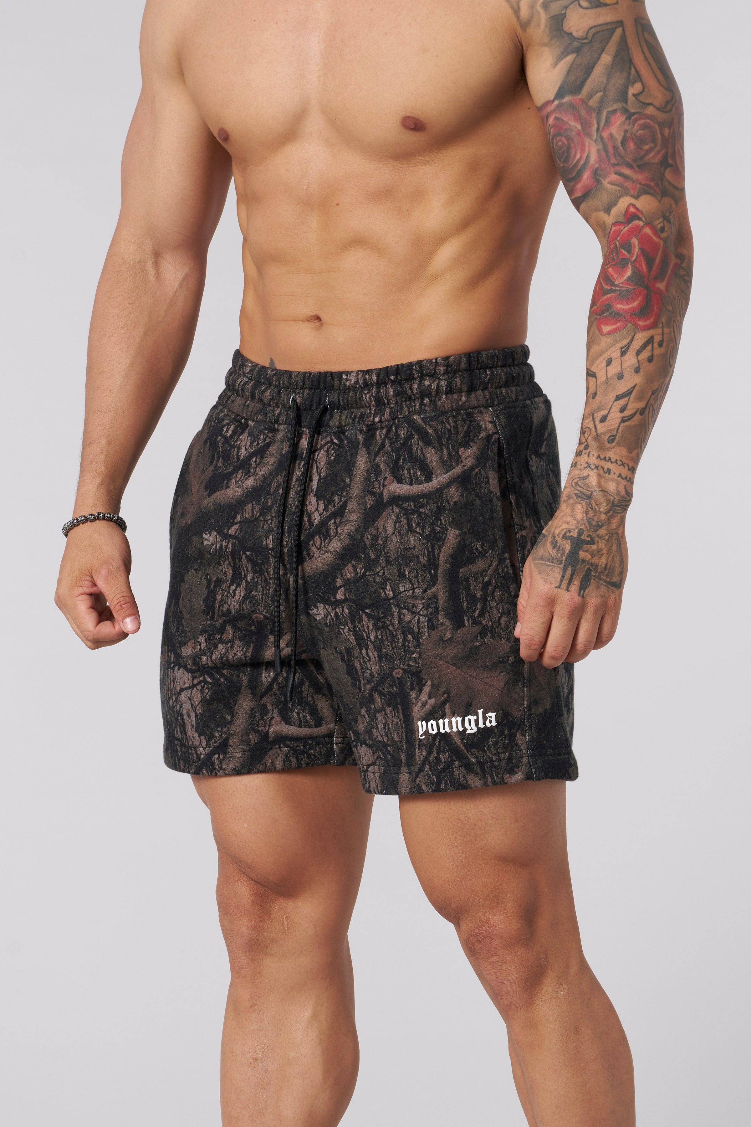 Tree camo cotton shorts on model during hike, showcasing relaxed fit.