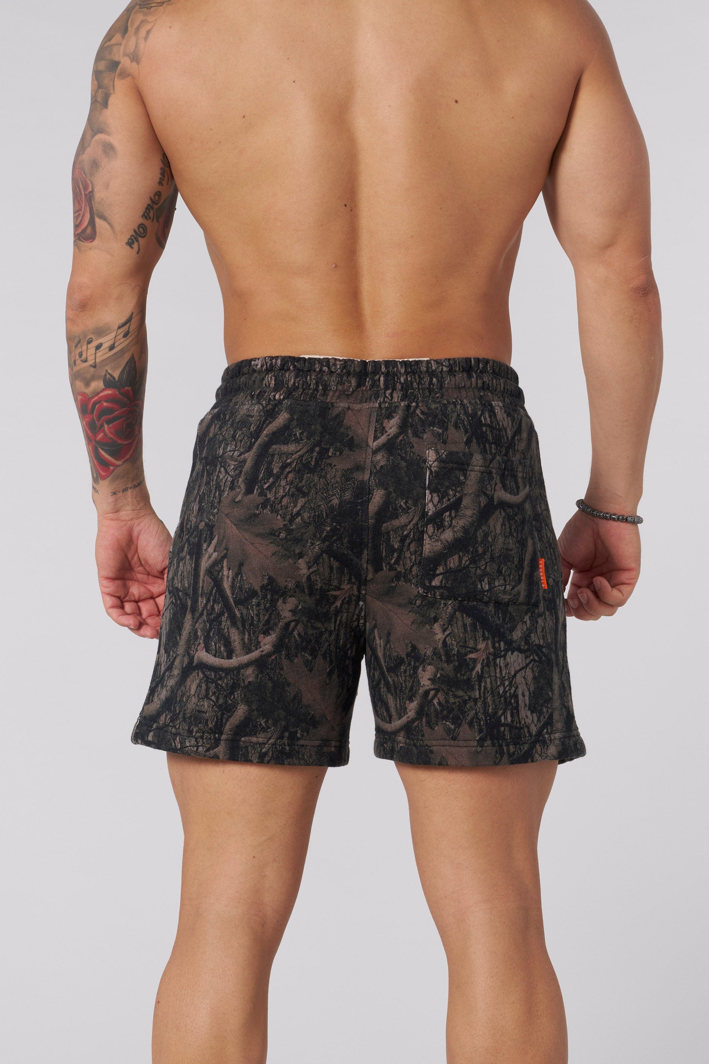 Tree camo cotton shorts on model during hike, showcasing relaxed fit.