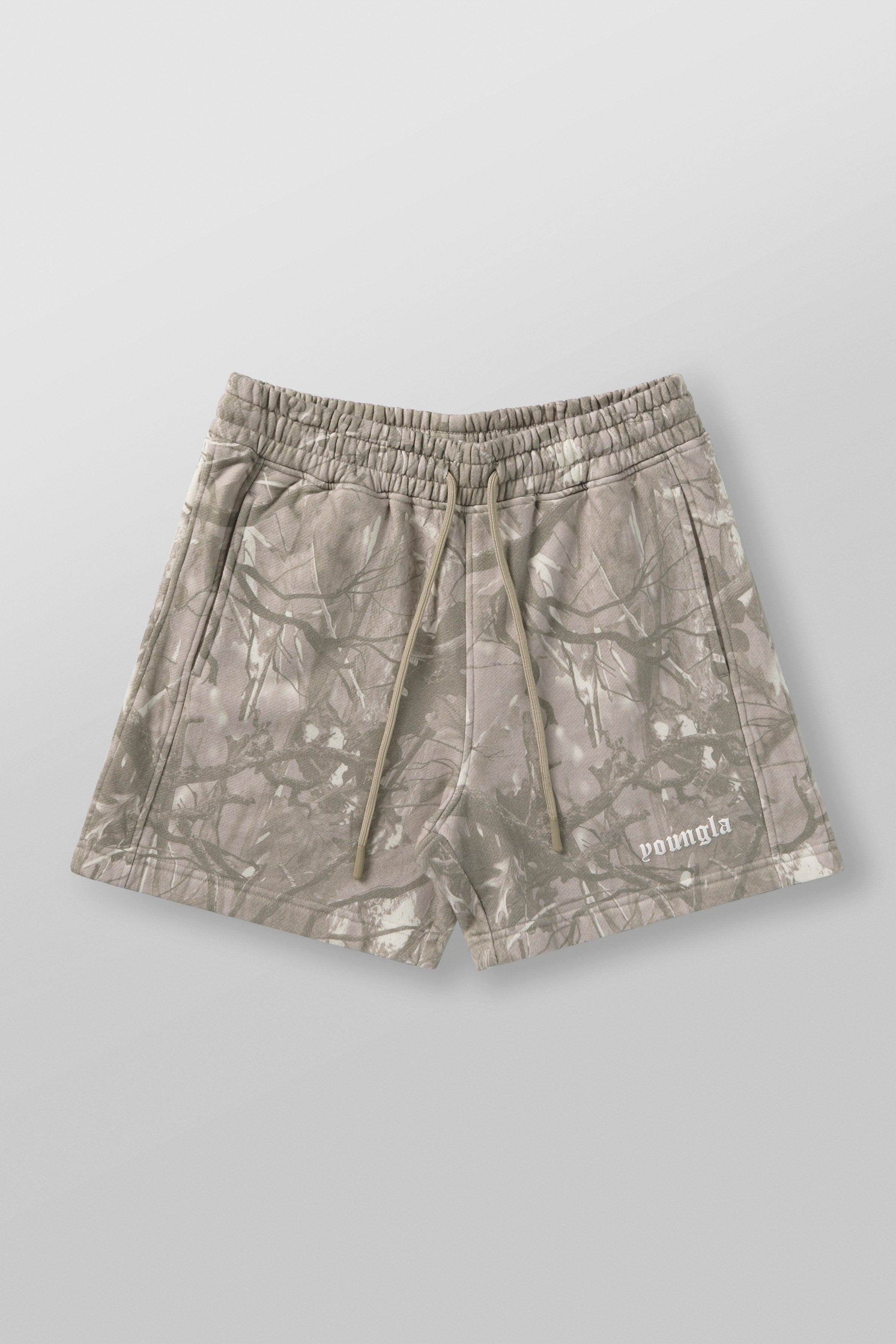 Tree camo cotton shorts on model during hike, showcasing relaxed fit.