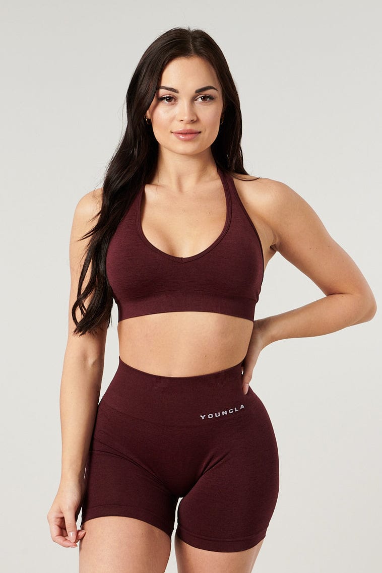 Back view of halter neck sports bra worn with open-back tank top