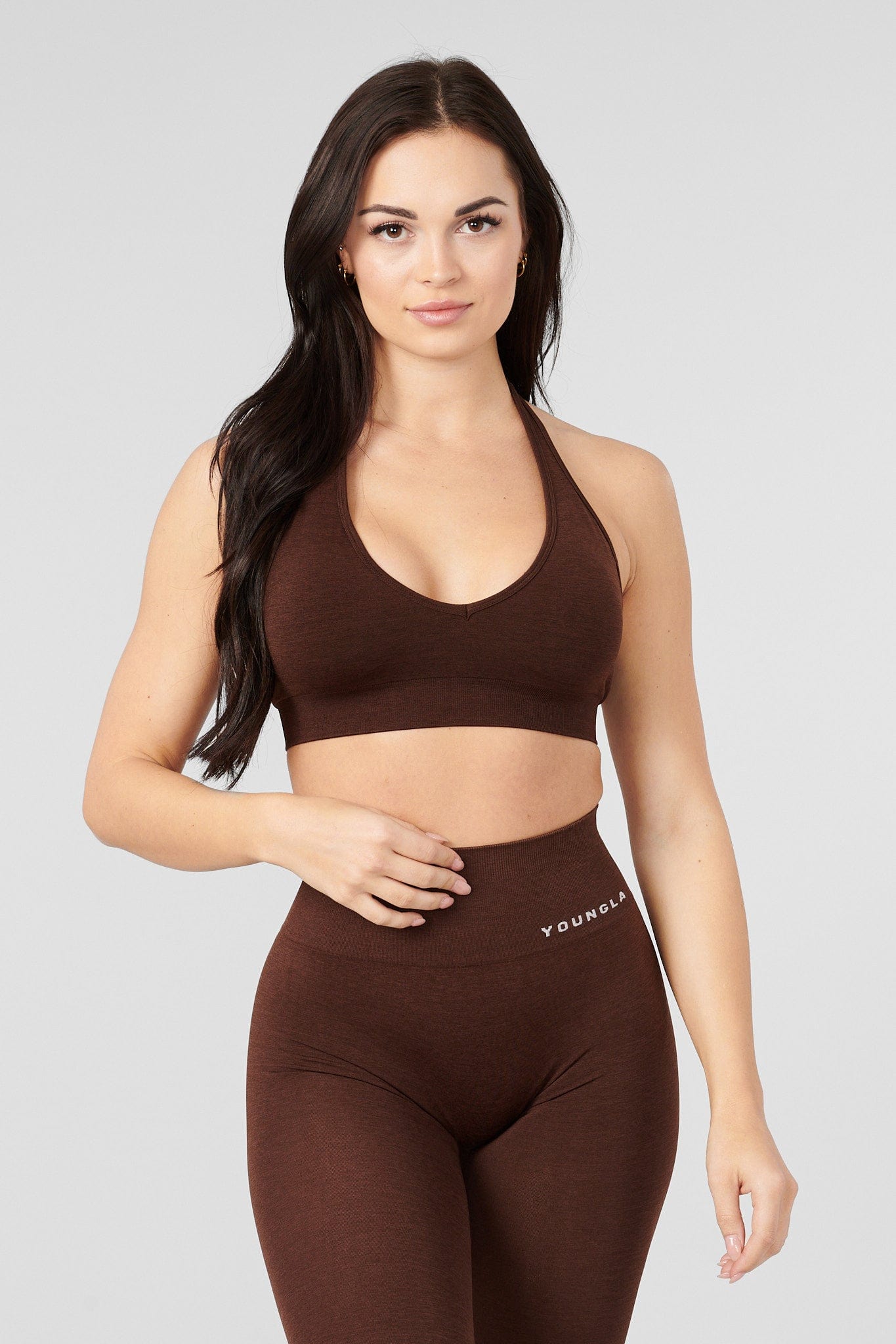 Back view of halter neck sports bra worn with open-back tank top