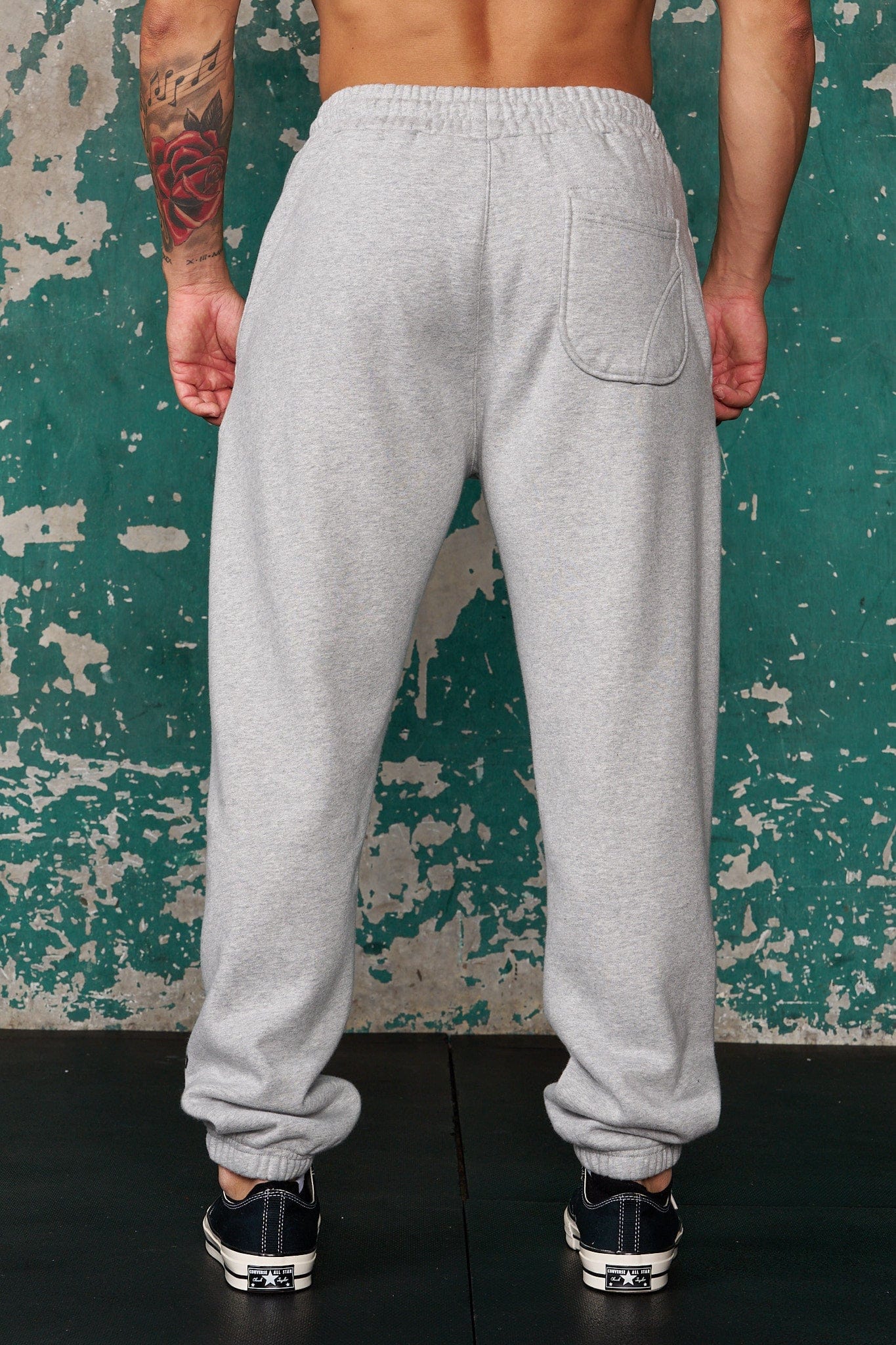 Close-up of Golds Gym logo detail on black cuffed joggers