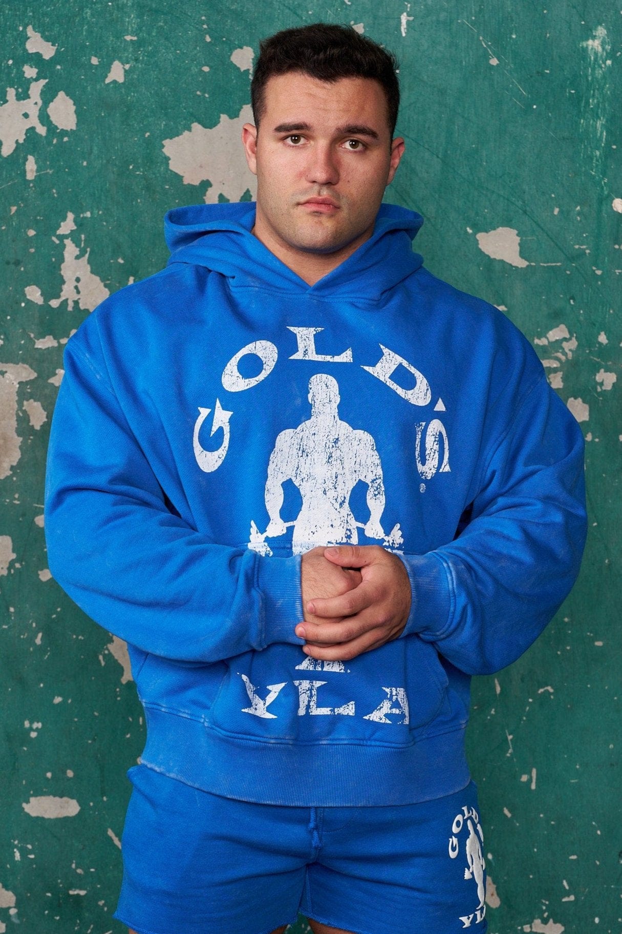 Side profile of model wearing terry fleece hoodie outdoors