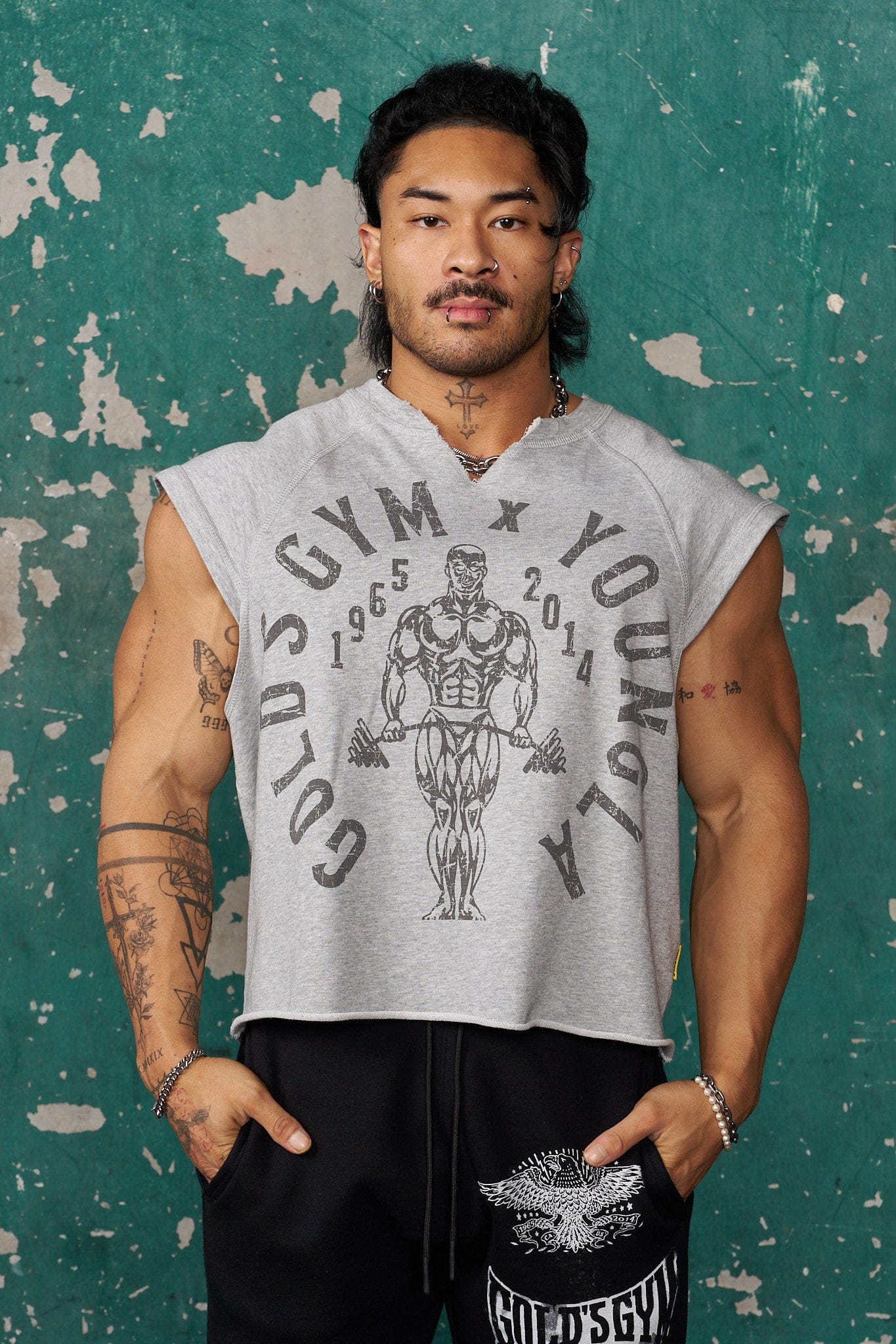 Model wearing Golds Gym vintage cut off shirt during workout.