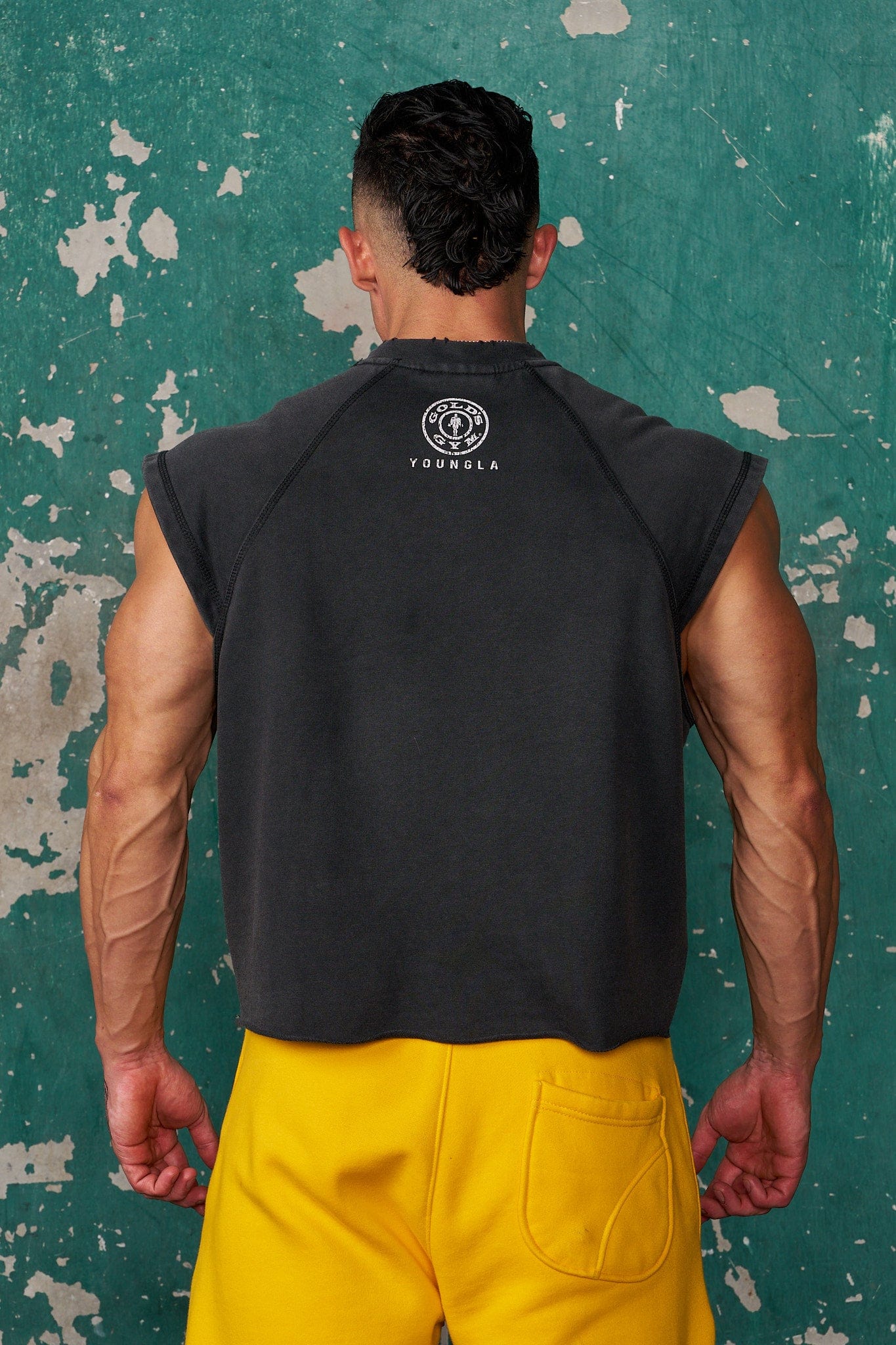 Front view of Golds Gym vintage cut off shirt in gym setting.