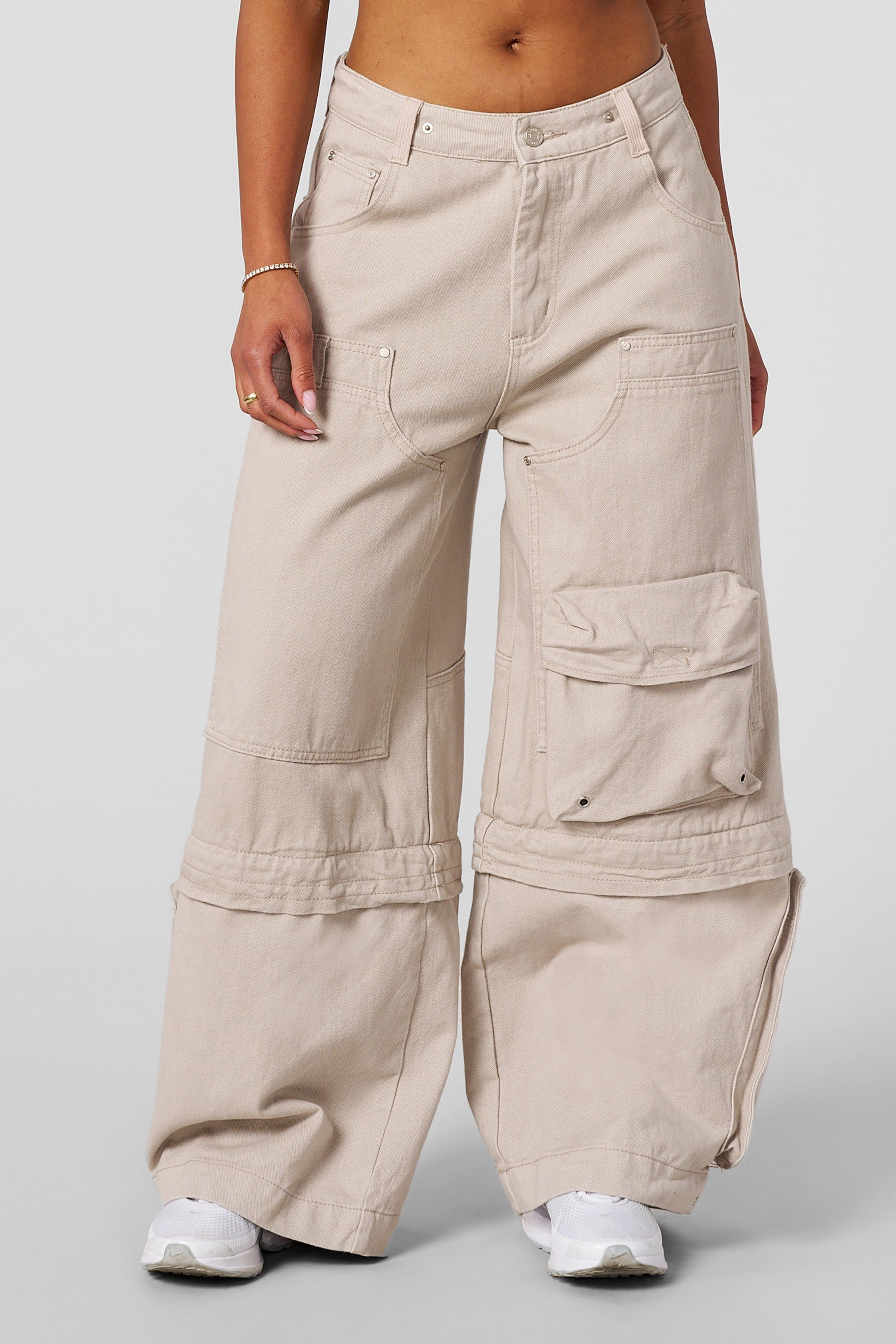 Wide leg carpenter jeans shown from side angle, paired with chunky sneakers