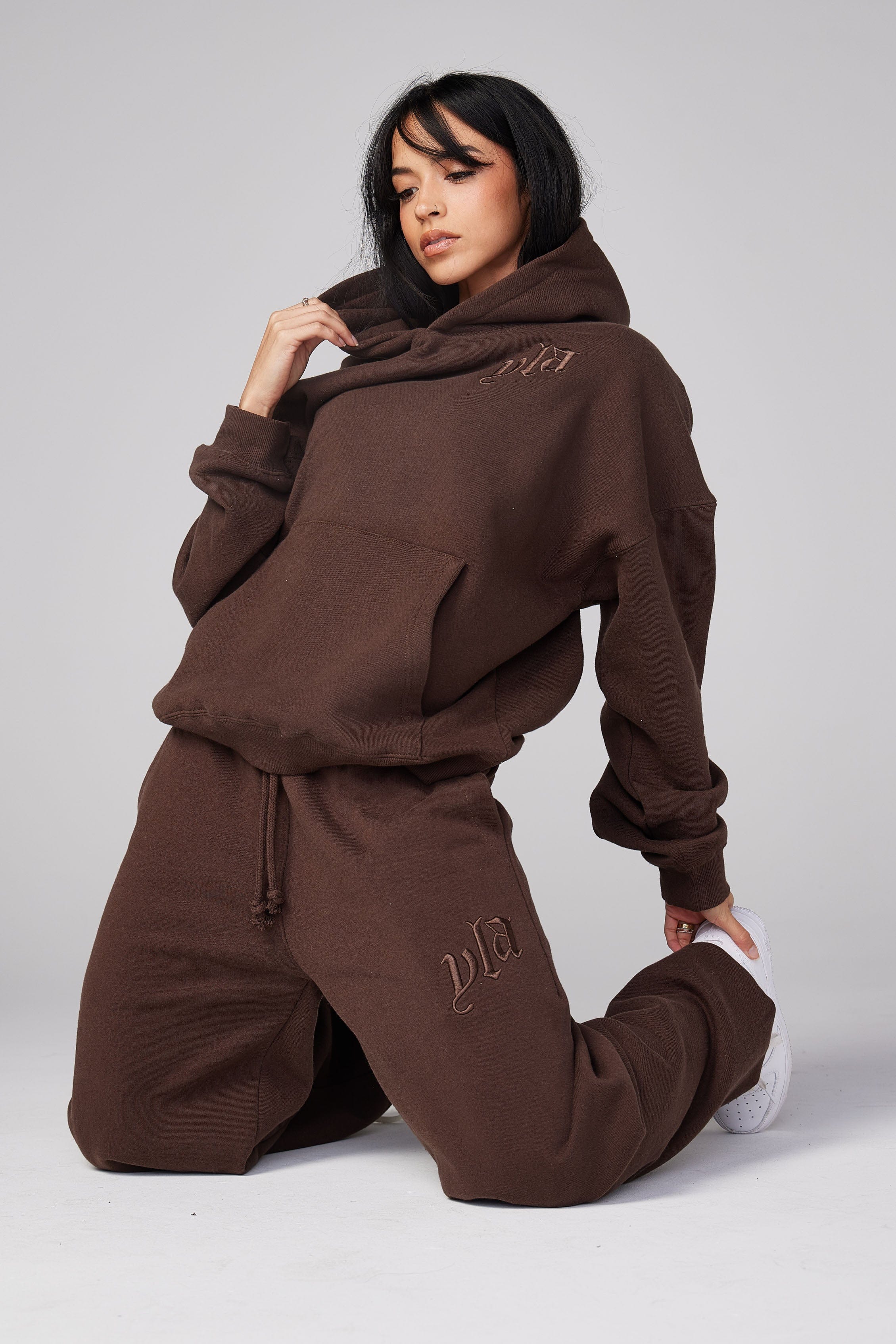Street-style shot of oversized hoodie with autumn leaves backdrop