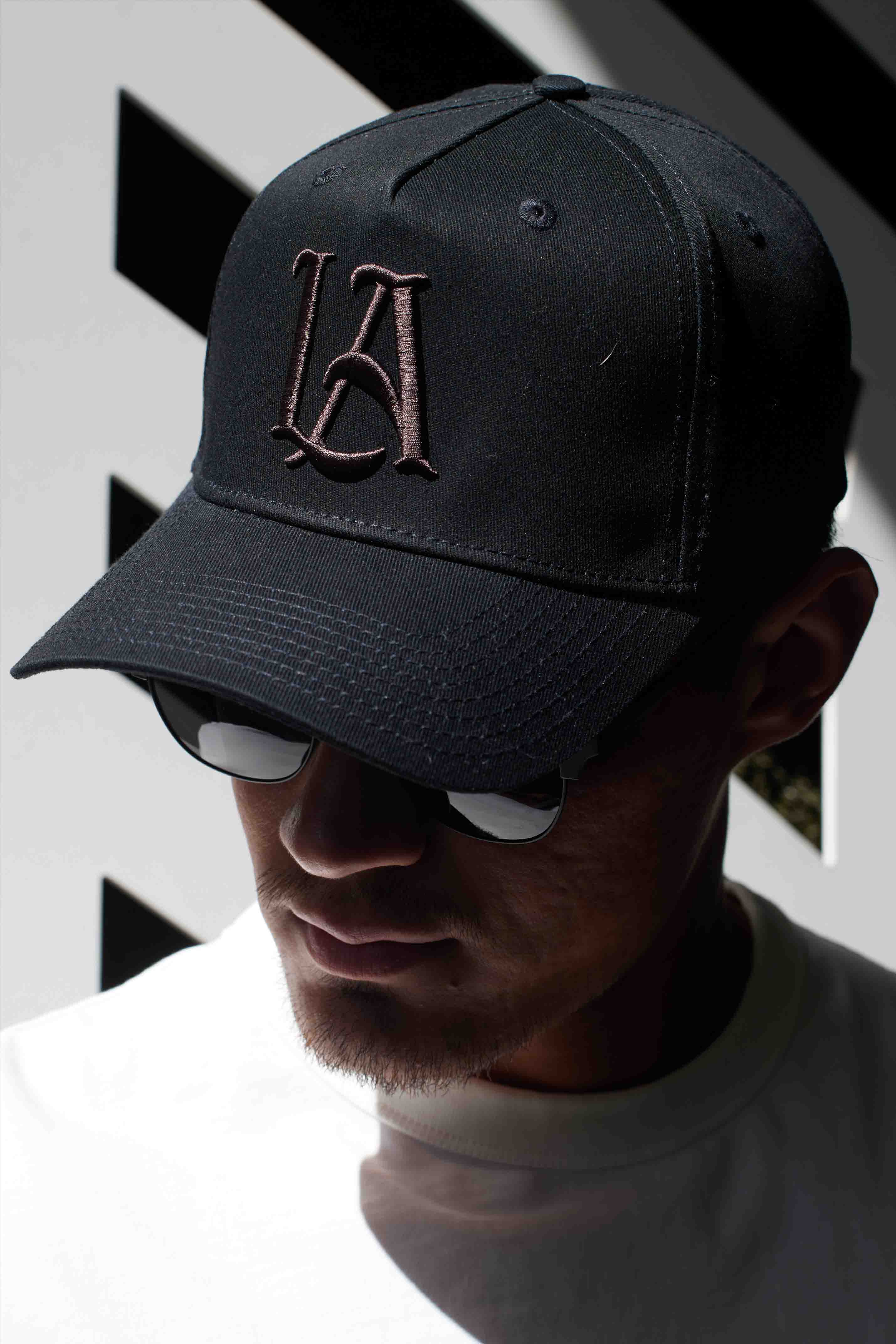 Side angle showing custom snapback hat fit and embroidery across twill fabric in earthy tones.