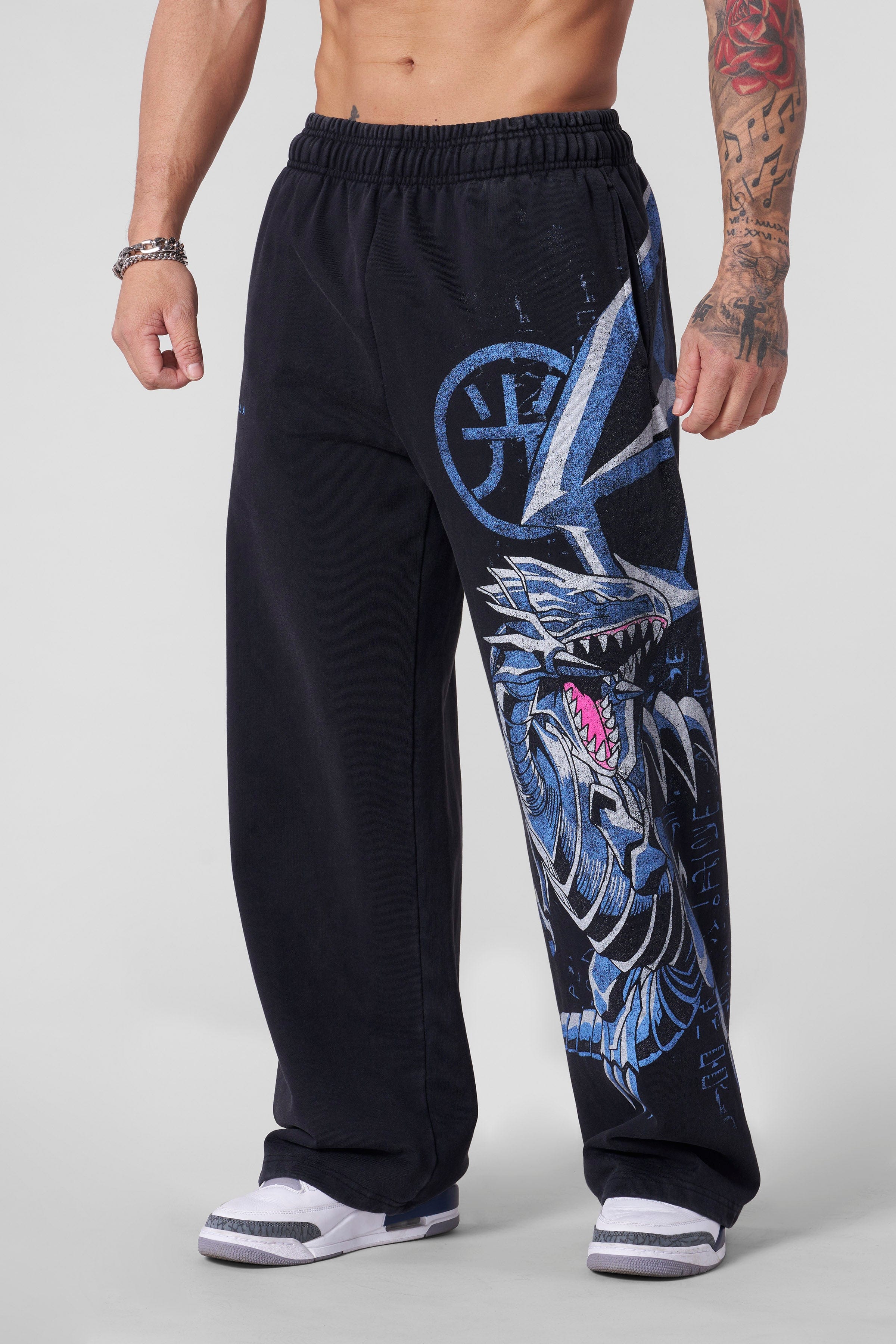 Model wearing baggy sweatpants with graphic design during relaxed outdoor activity