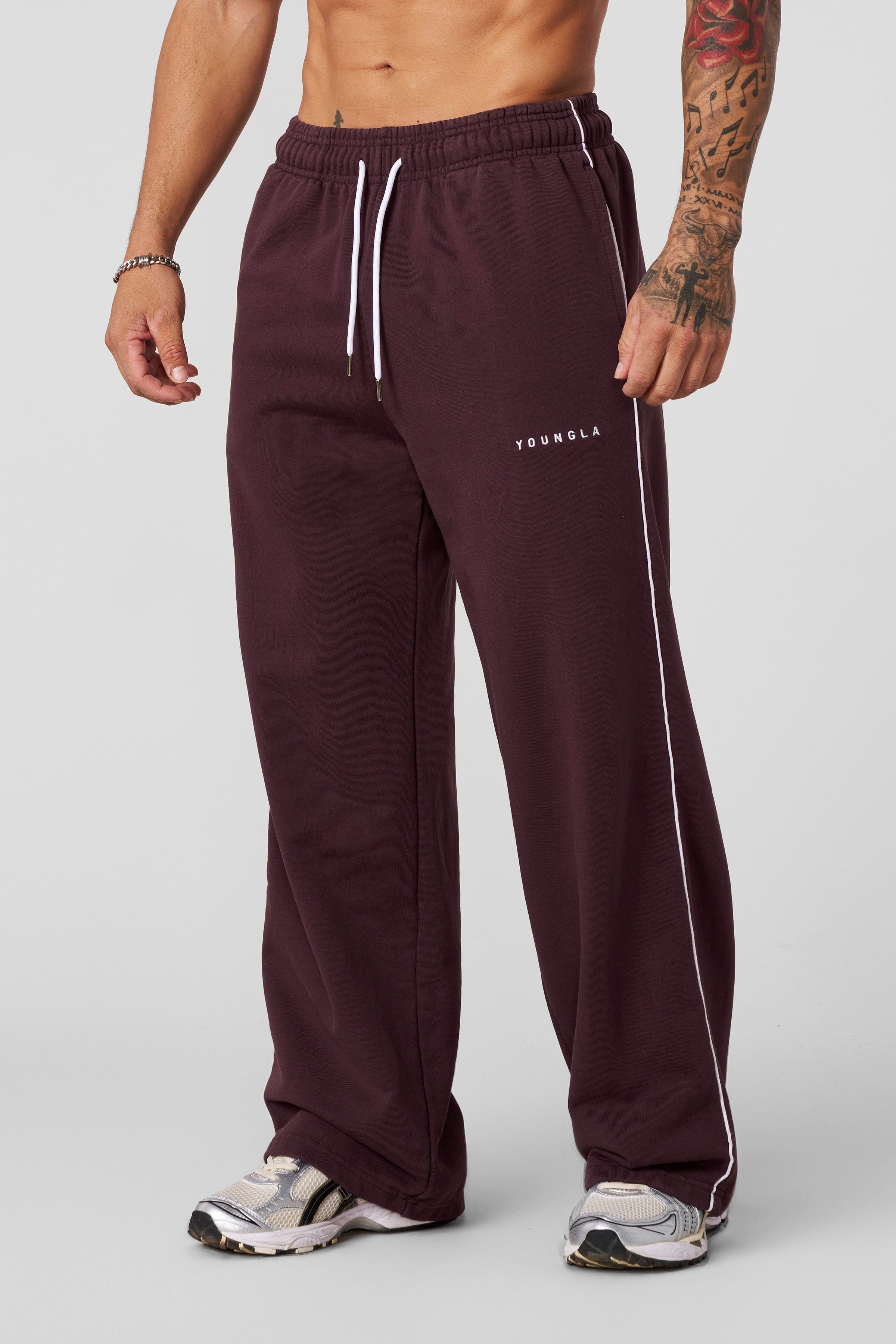 Model wearing baggy gray sweatpants in a relaxed outdoor setting
